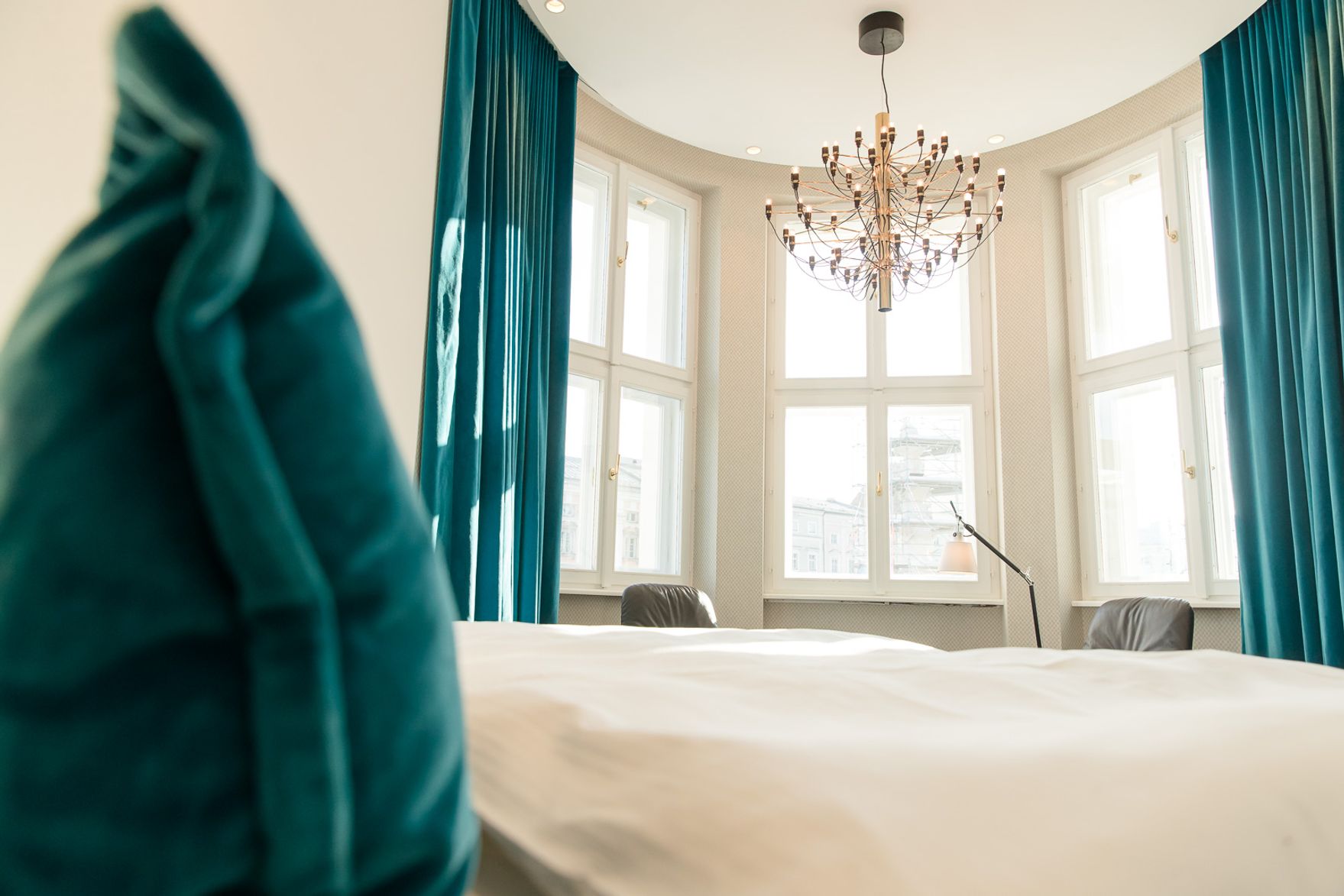 designhotel Linz Hauptplatz Motel One view over the bed to the windows of a bay window with sunlight