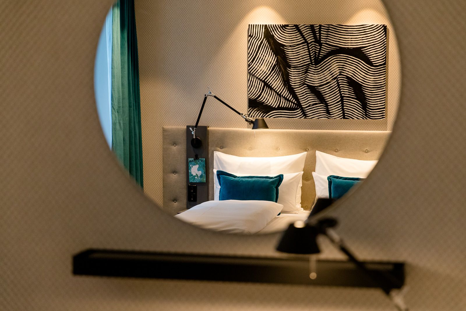Designhotel Linz Hauptplatz Motel One Blick durch runden Spiegel auf Doppelbett