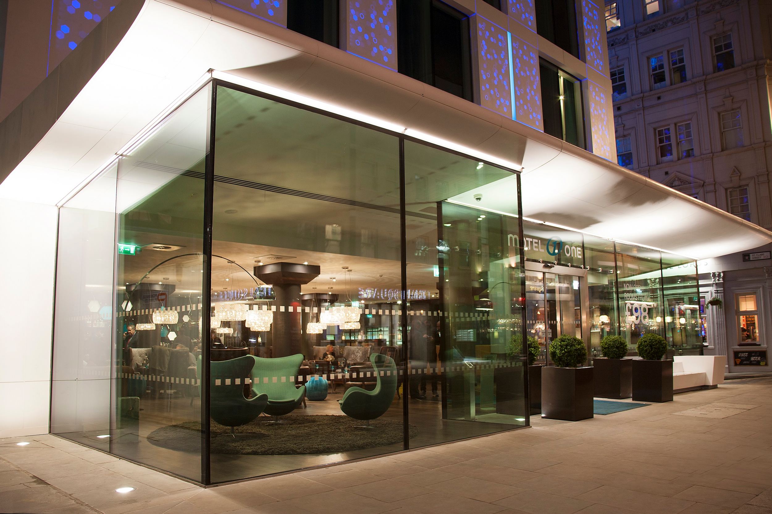 hotel London Tower Hill Motel One entrance area with large glass fronts in the evening