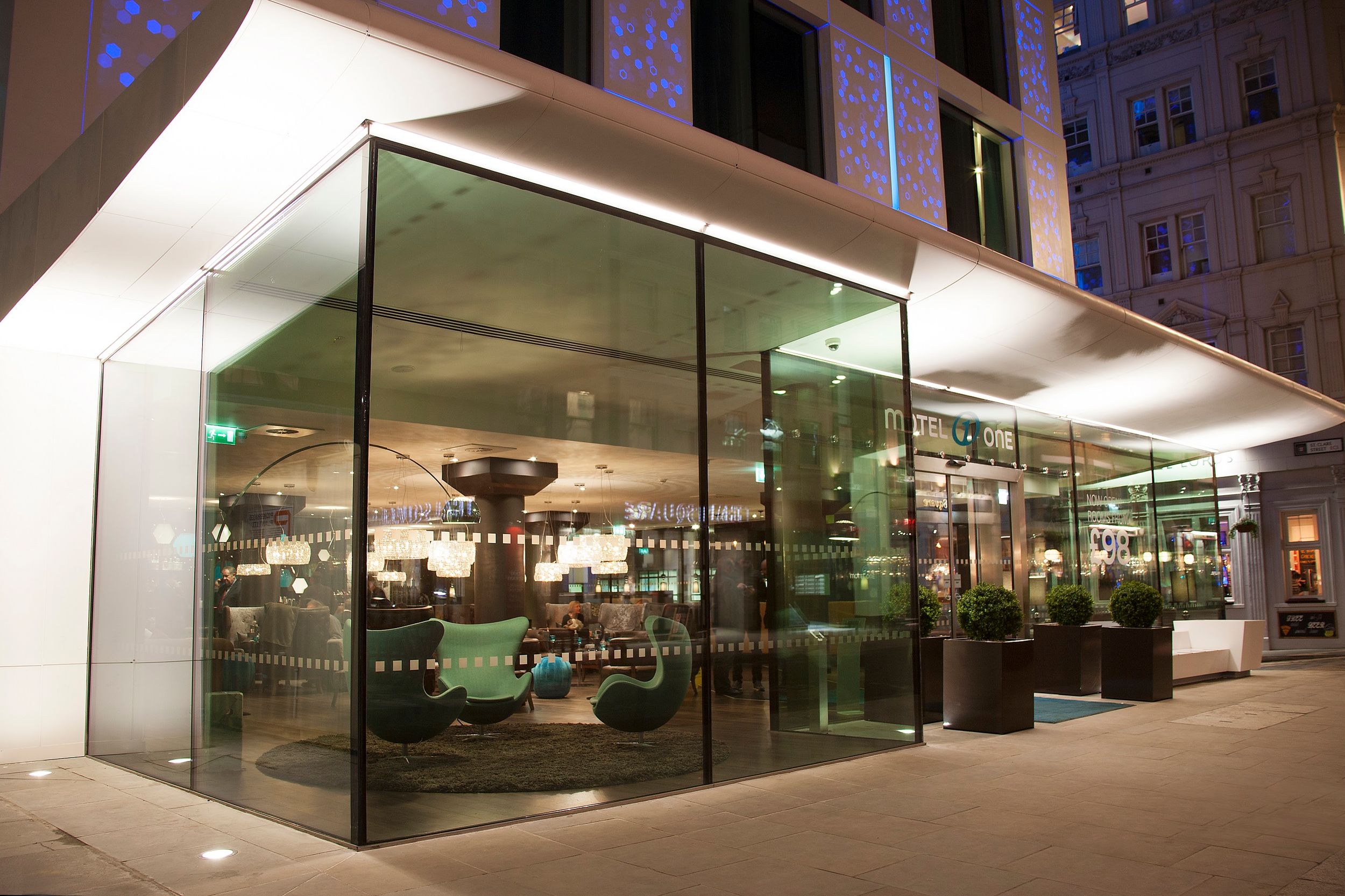 Hotel London Tower Hill Motel One Eingangsbereich mit großen Glasfronten bei Abend