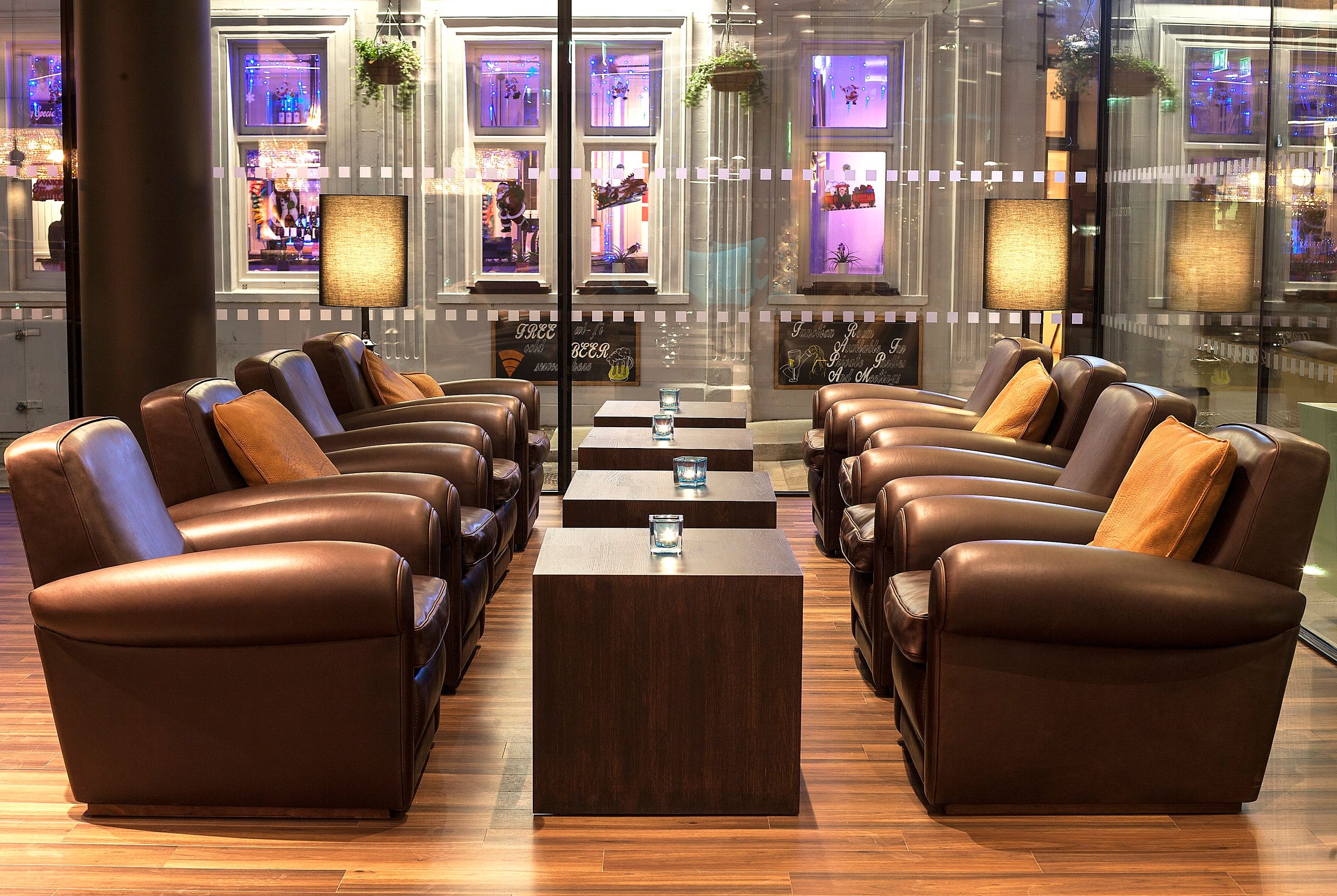 Hotel London Tower Hill Motel One Lounge mit acht Sesseln und vier Tischen vor großer Glasfront