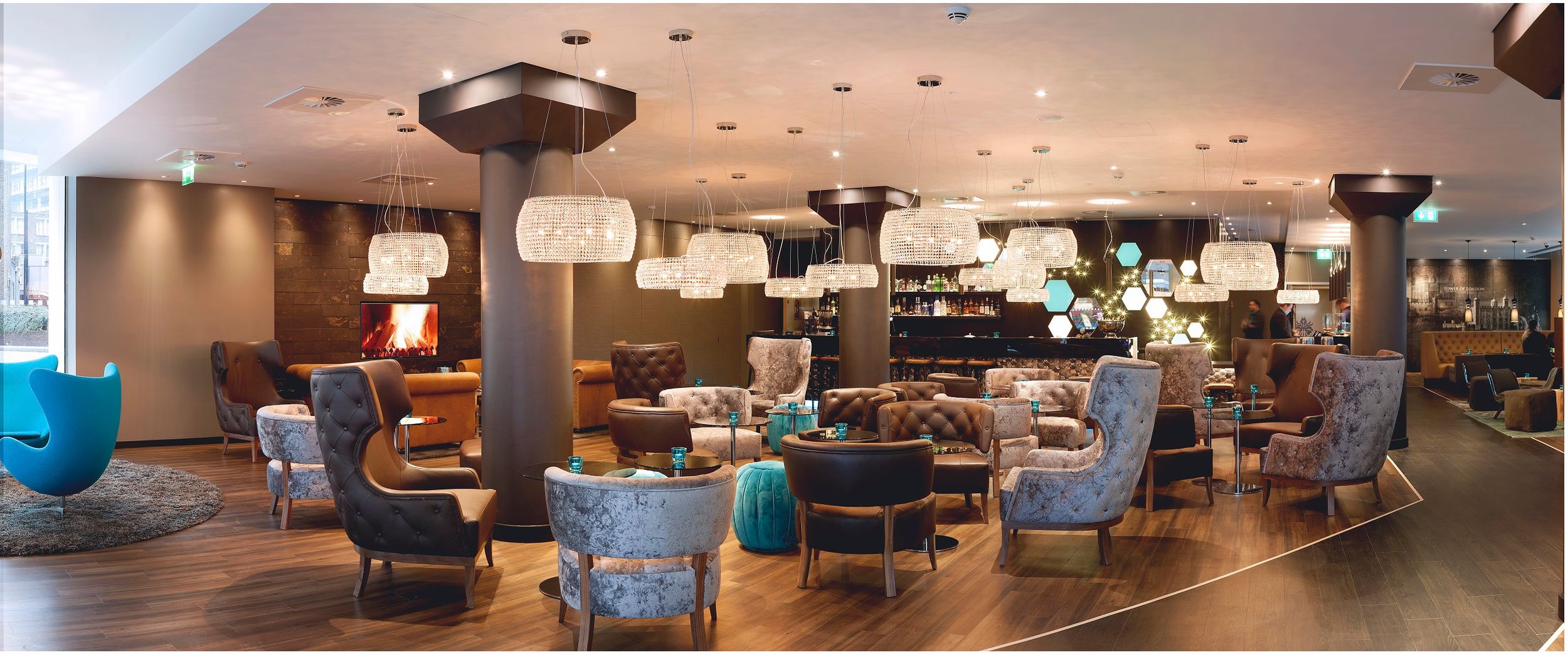 Hotel London Tower Hill Motel One große Lounge mit mehreren Sesseln und Bar im Hintergrund