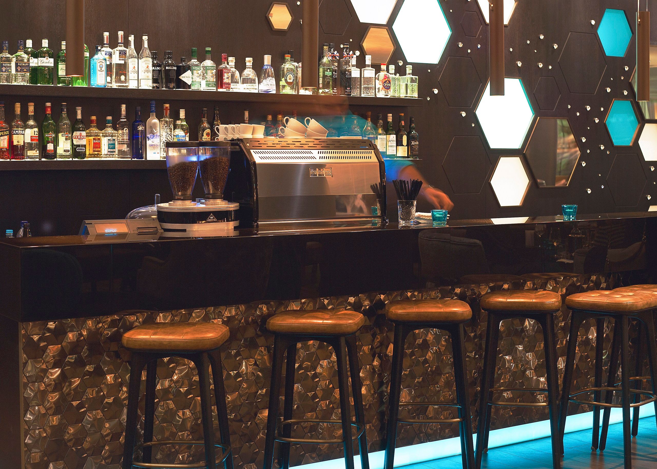Hotel London Tower Hill Motel One Bar mit Mitarbeiter sowie mehrere Barhocker an dem Tresen