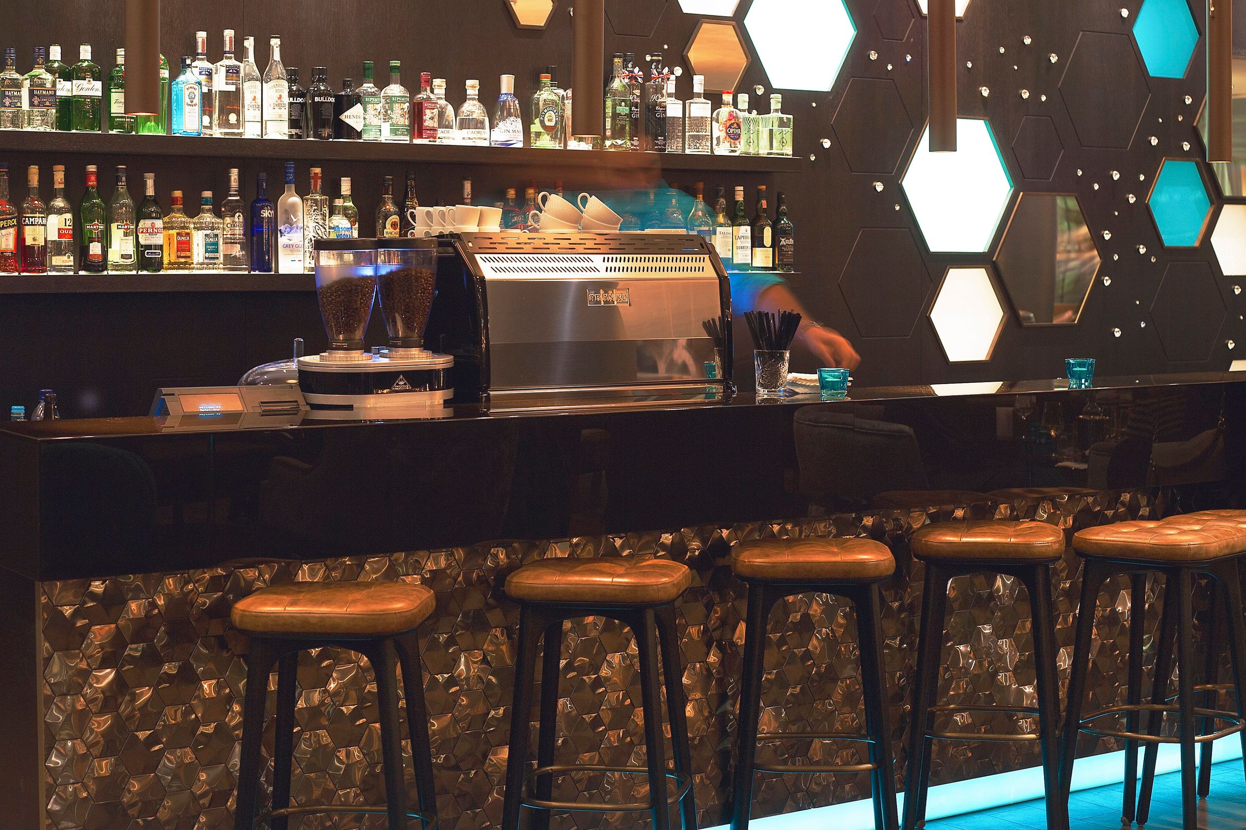 hotel London Tower Hill Motel One bar with staff and several bar stools at the counter