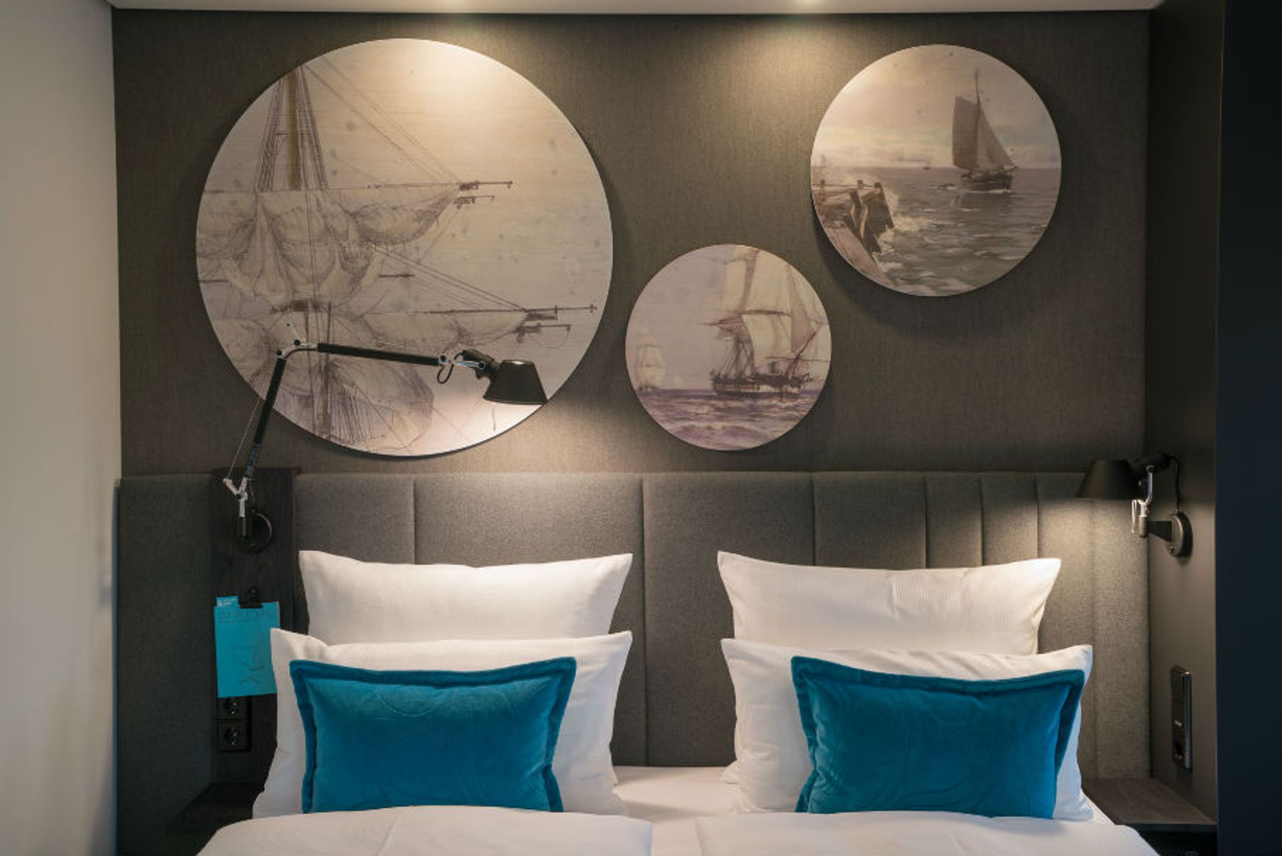 Hotel Lübeck Motel One Zimmer mit Blick auf Doppelbett mit Zierkissen
