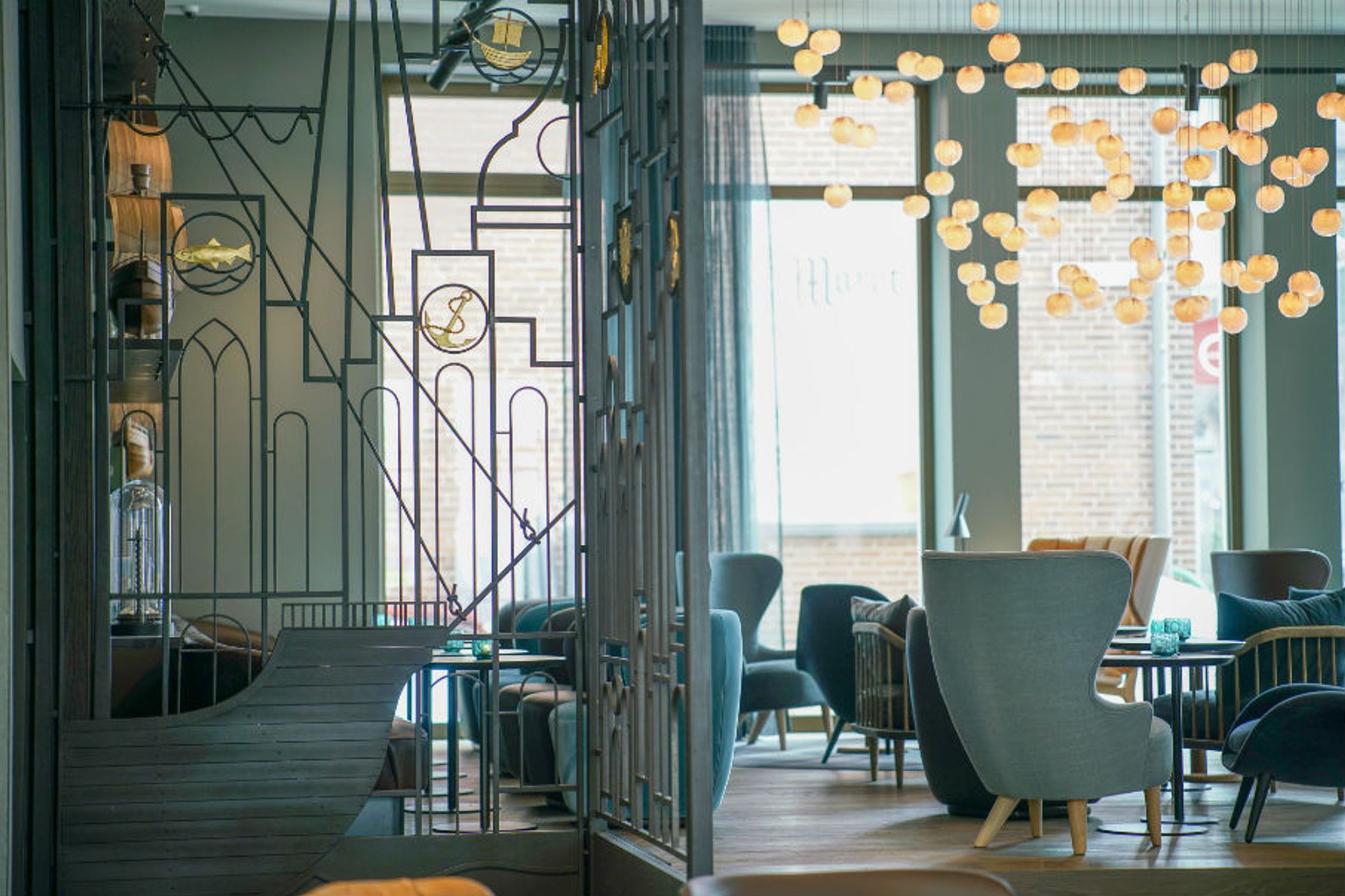 Hotel Lübeck Motel One Lounge mit zahlreichen Sesseln und bodentiefen Fenstern