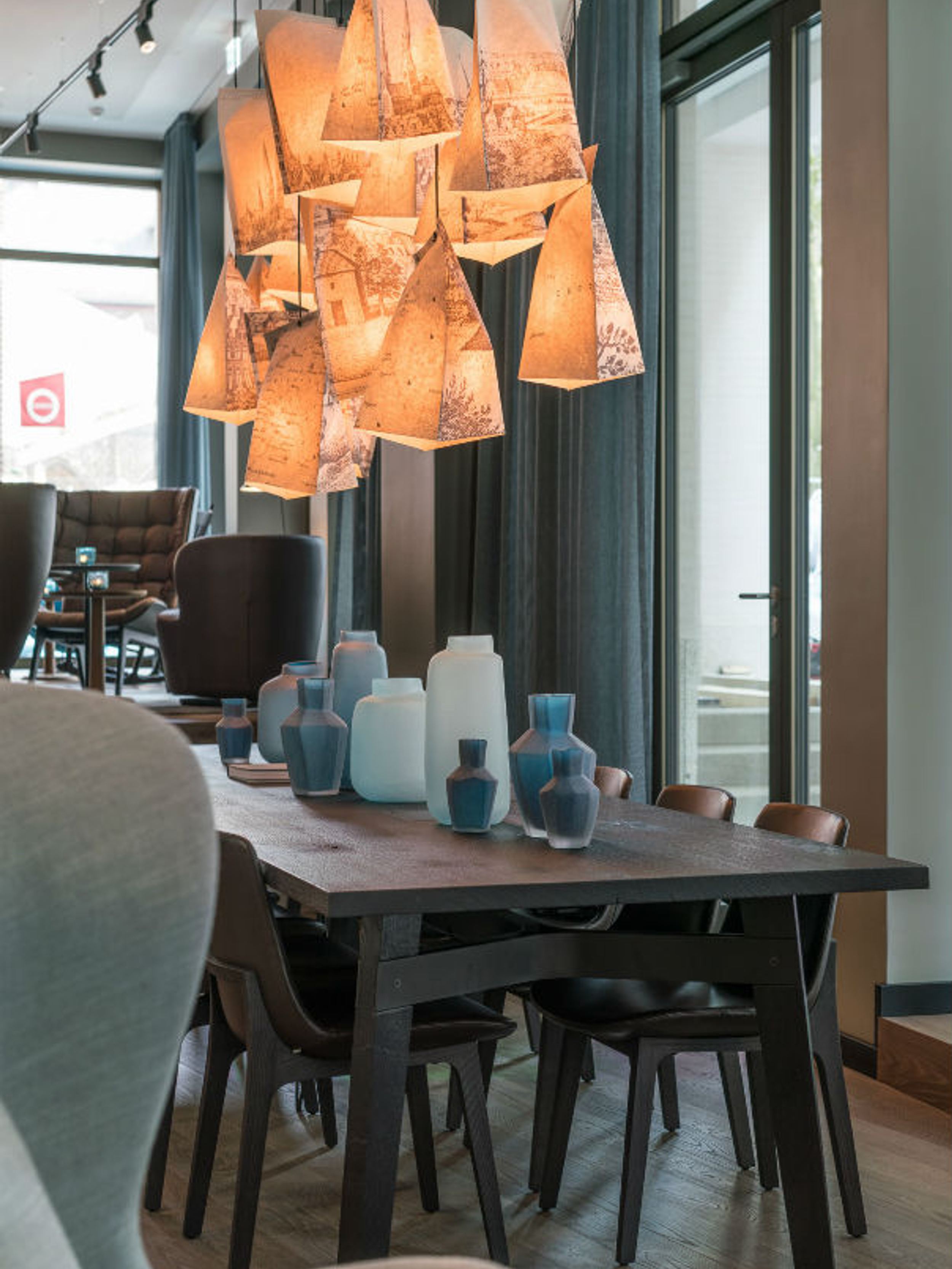 Hotel Lübeck Motel One langer Tisch mit mehreren Stühlen in lichtdurchfluteter Lounge