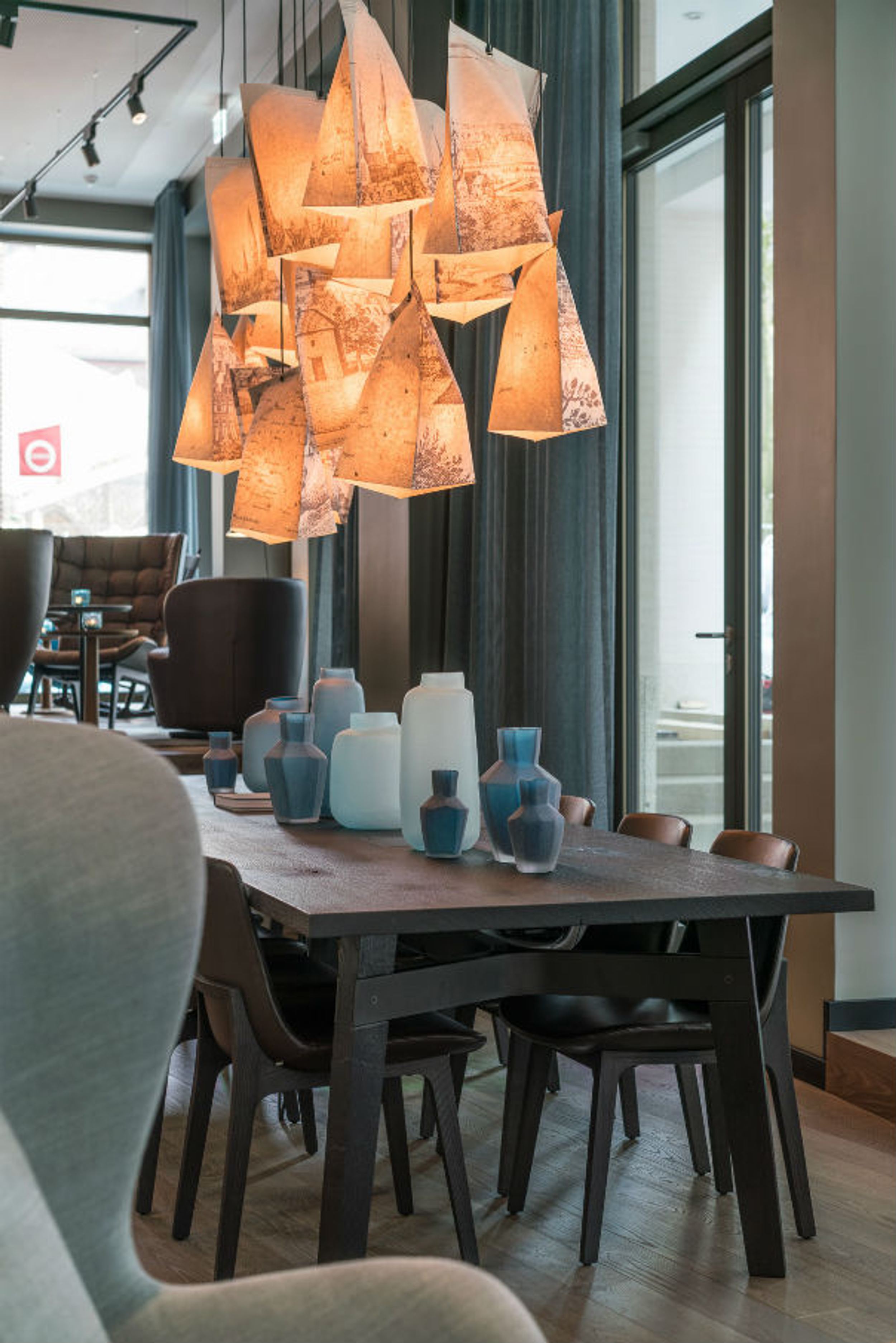 Hotel Lübeck Motel One langer Tisch mit mehreren Stühlen in lichtdurchfluteter Lounge