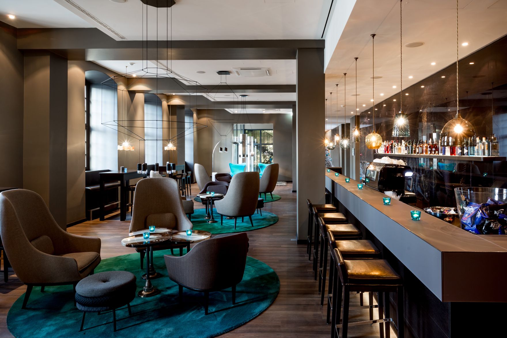 Hotel Magdeburg Motel One seitlicher Blick auf lange Bar mit Barhockern sowie mehrere Sessel in der Lounge