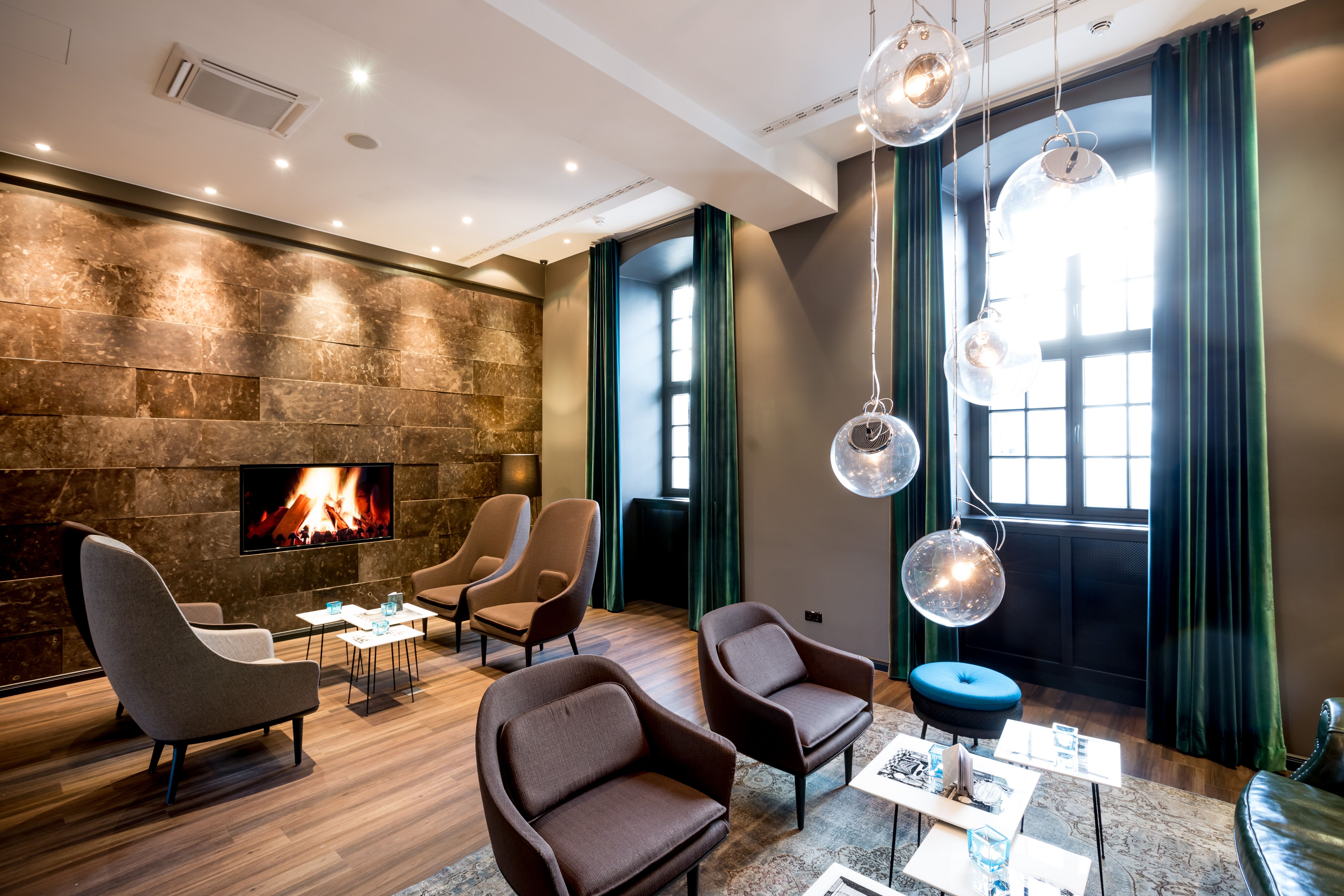Hotel Magdeburg Motel One helle Lounge mit zwei großen Fenstern und mehreren Sitzgelegenheiten