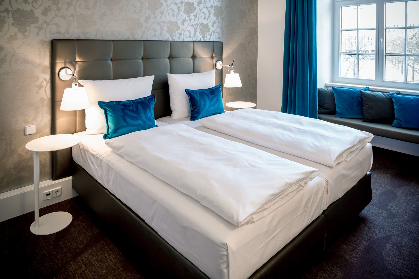 Hotel Magdeburg Motel One Zimmer mit einem Doppelbett und einer Sitzbank vor dem Fenster, das für viel Tageslicht sorgt