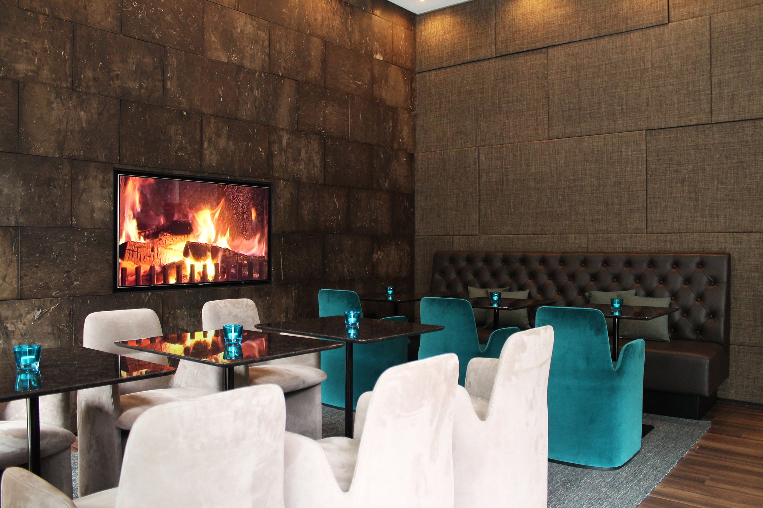 Hotel Manchester Piccadilly Motel One mehrere Tische und Stühle sowie Fernseher mit Feuer an der Wand