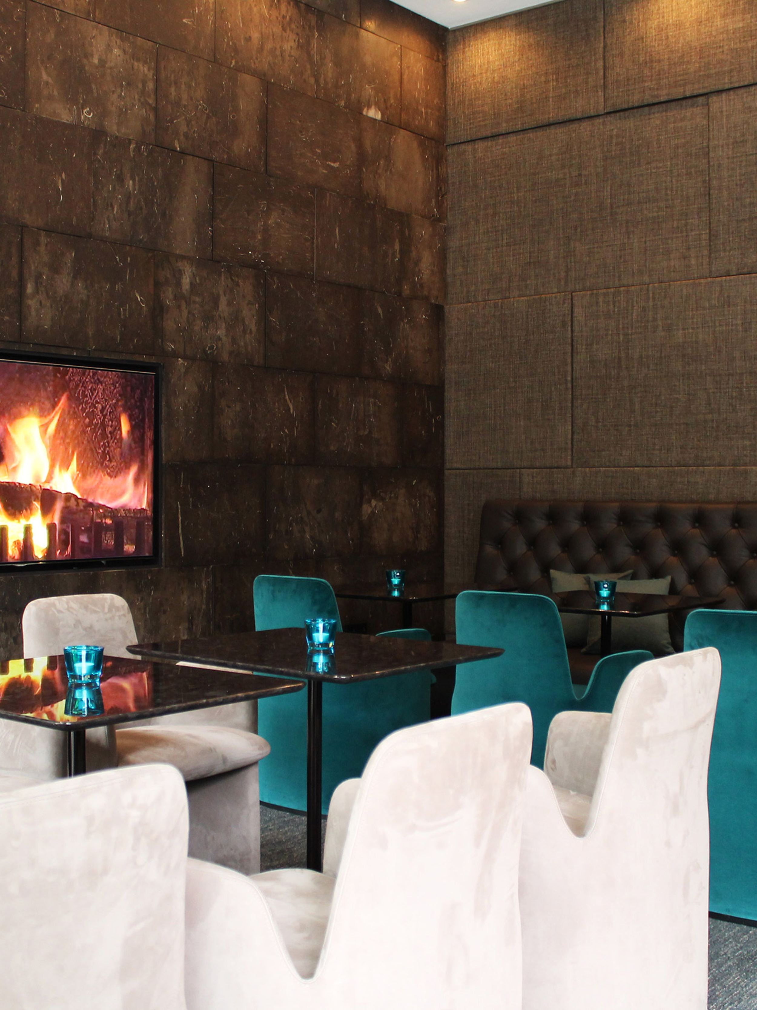 Hotel Manchester Piccadilly Motel One mehrere Tische und Stühle sowie Fernseher mit Feuer an der Wand