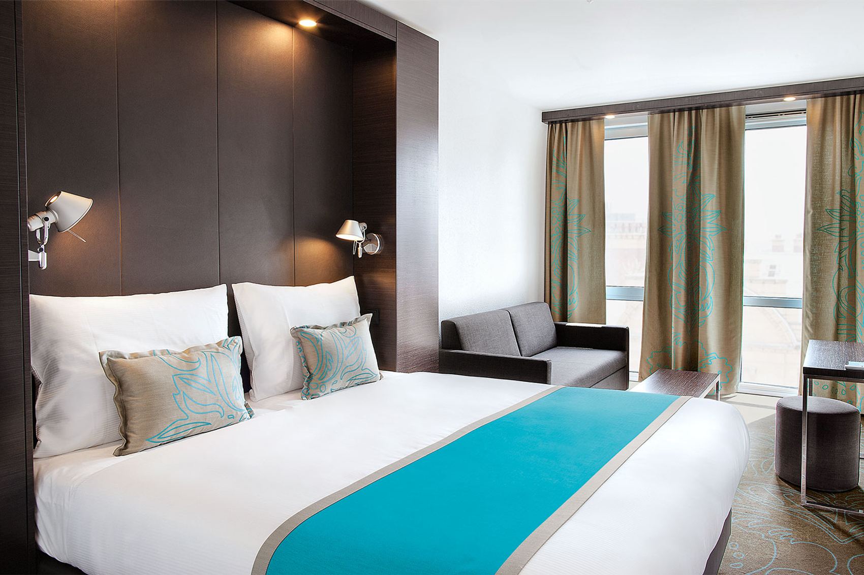 Designhotel Manchester Piccadilly Motel One geräumiges Zimmer mit Doppelbett, Sofa, Schreibtisch und Hocker