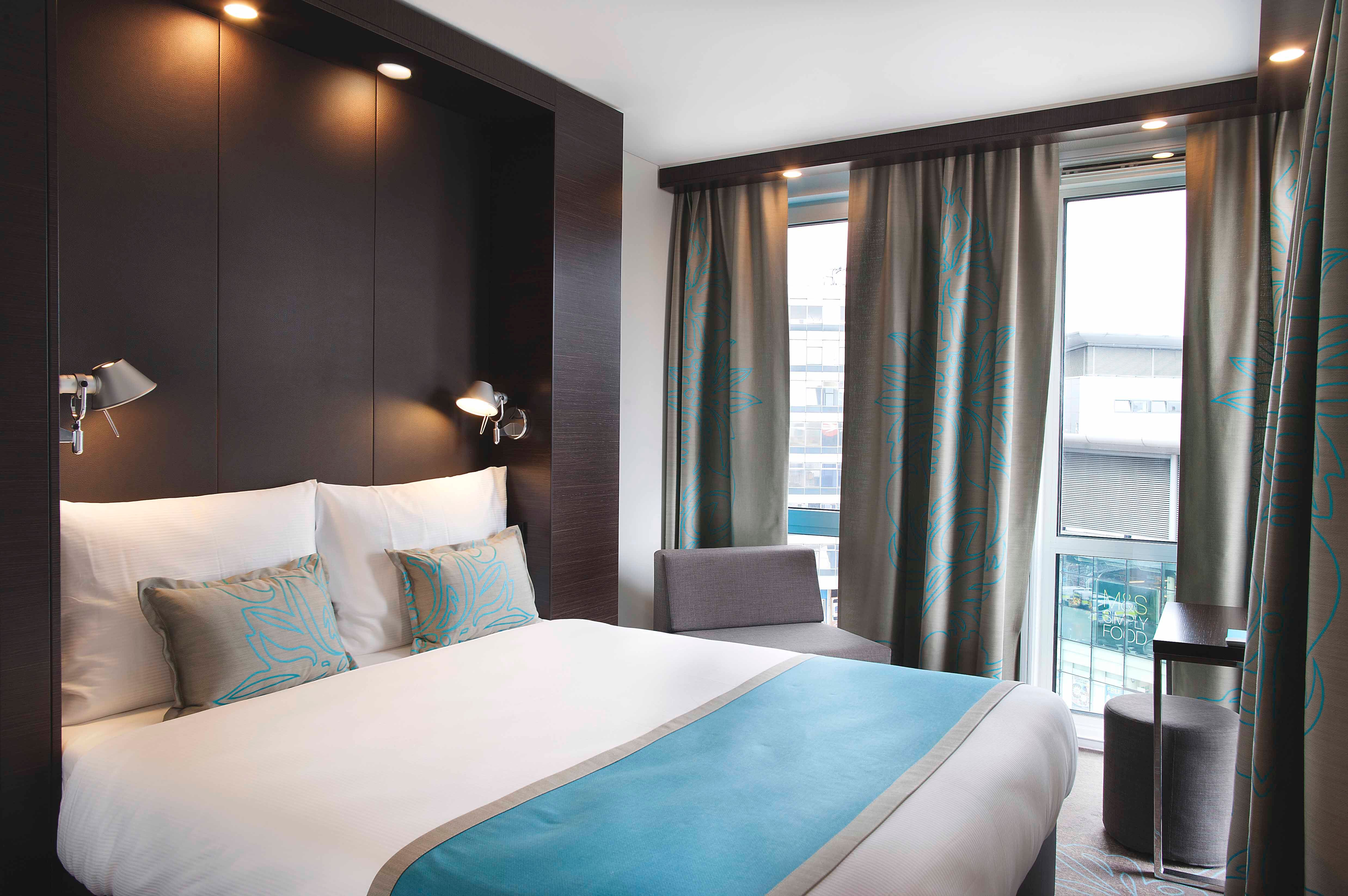 Hotel Manchester Piccadilly Motel One Zimmer mit Doppelbett und Zierkissen sowie Sessel