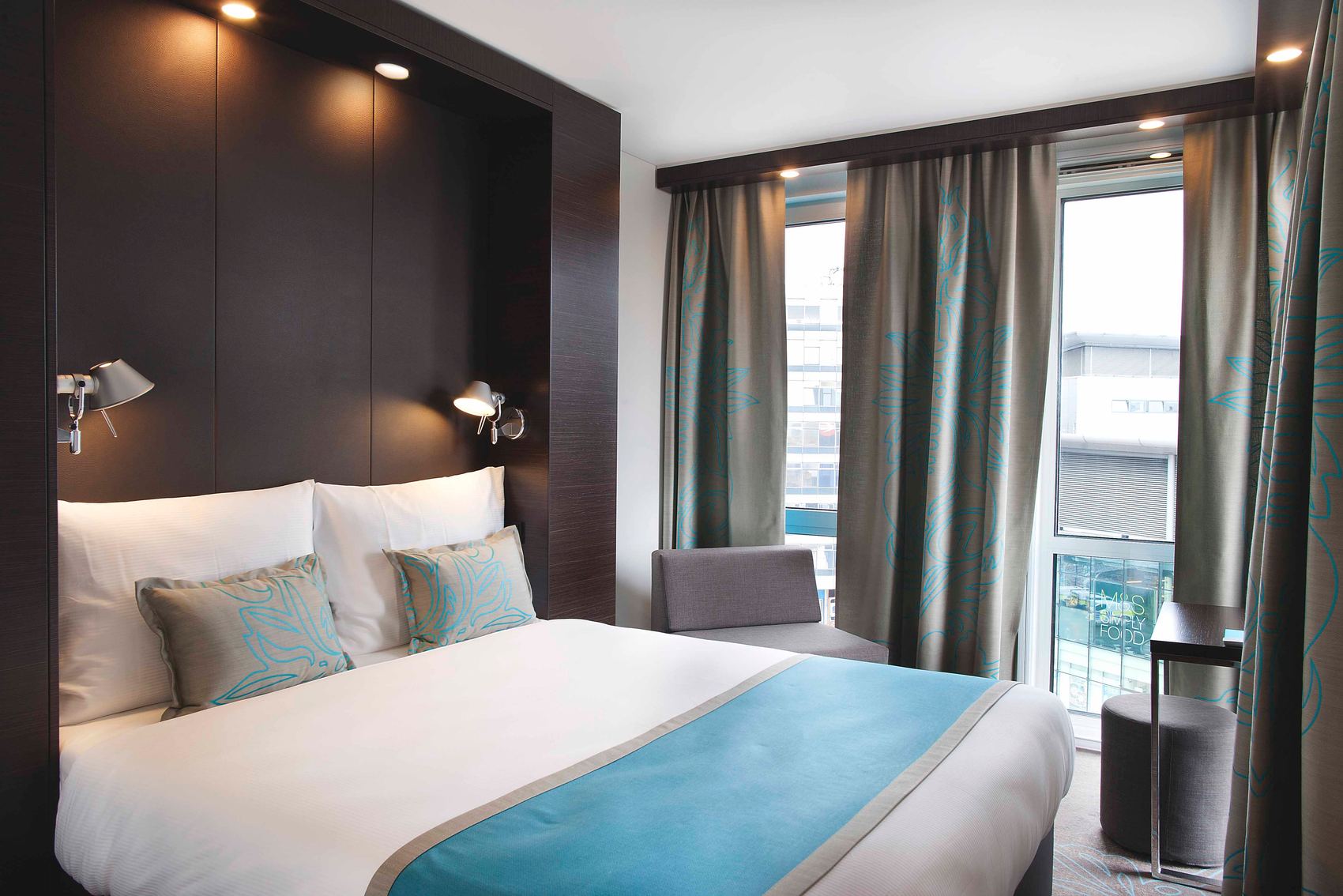 Hotel Manchester Piccadilly Motel One Zimmer mit Doppelbett und Zierkissen sowie Sessel