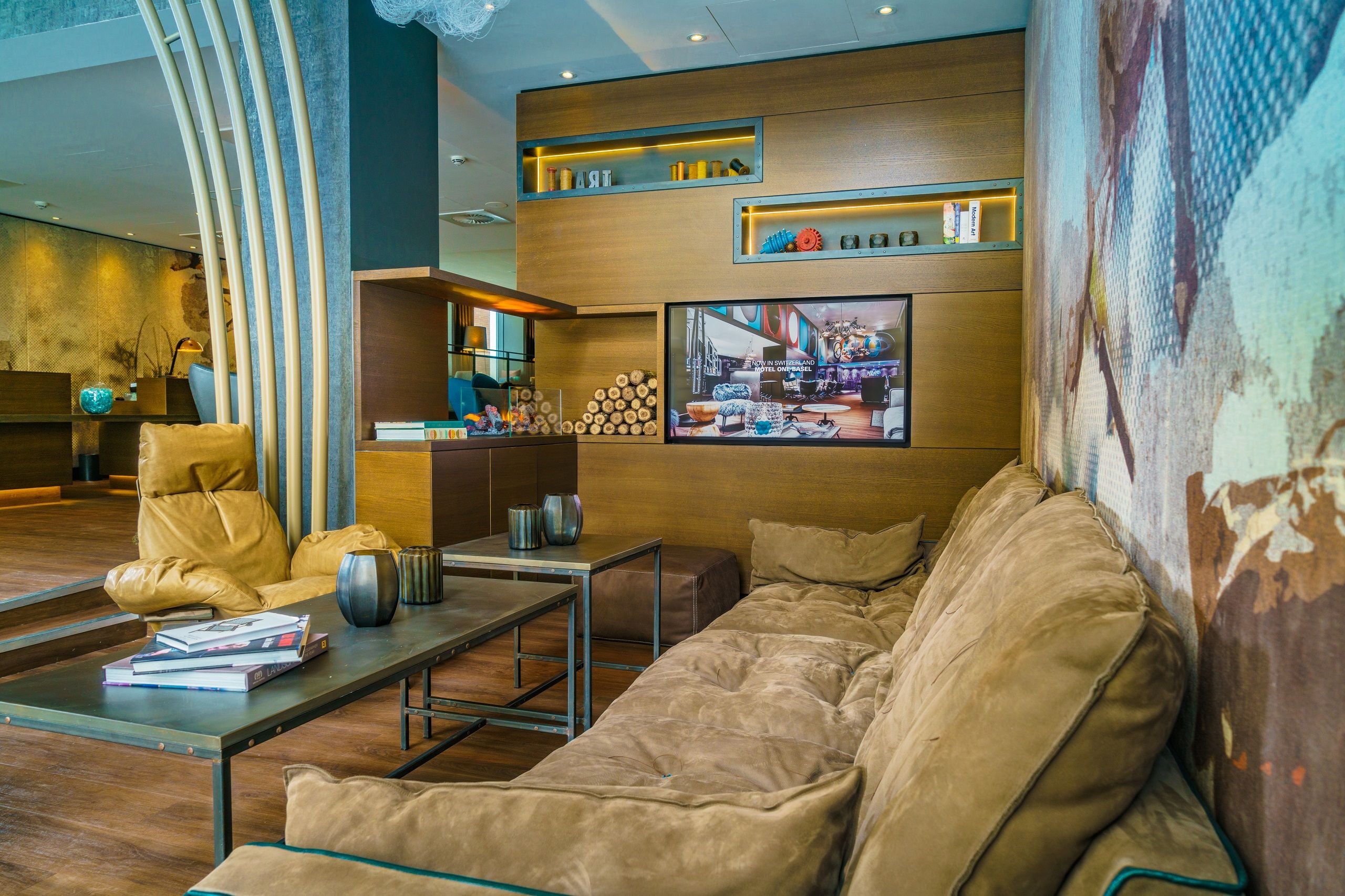 hotel Manchester Royal Exchange Motel One lounge with couch, armchair and TV on the wall