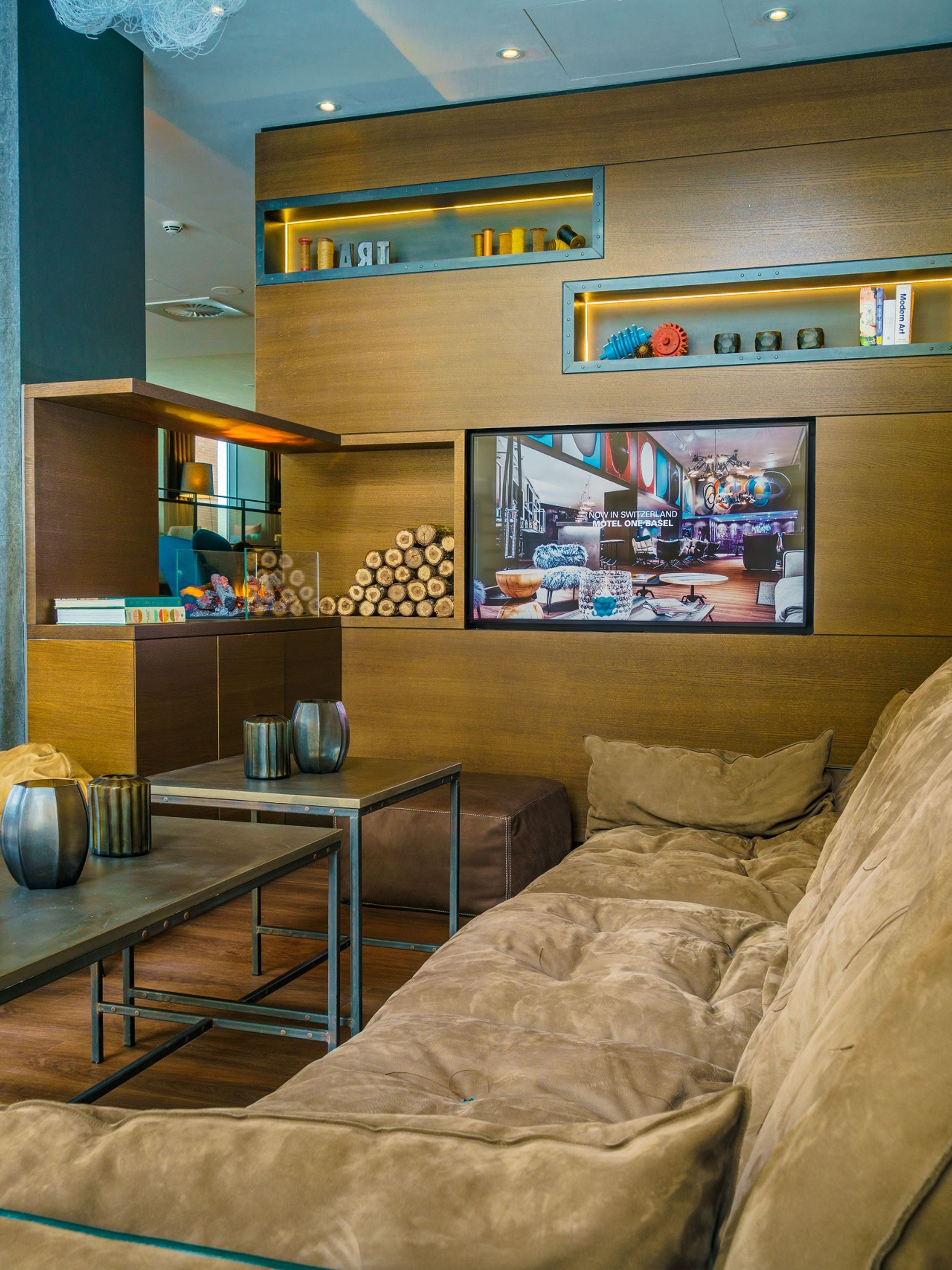 hotel Manchester Royal Exchange Motel One lounge with couch, armchair and TV on the wall