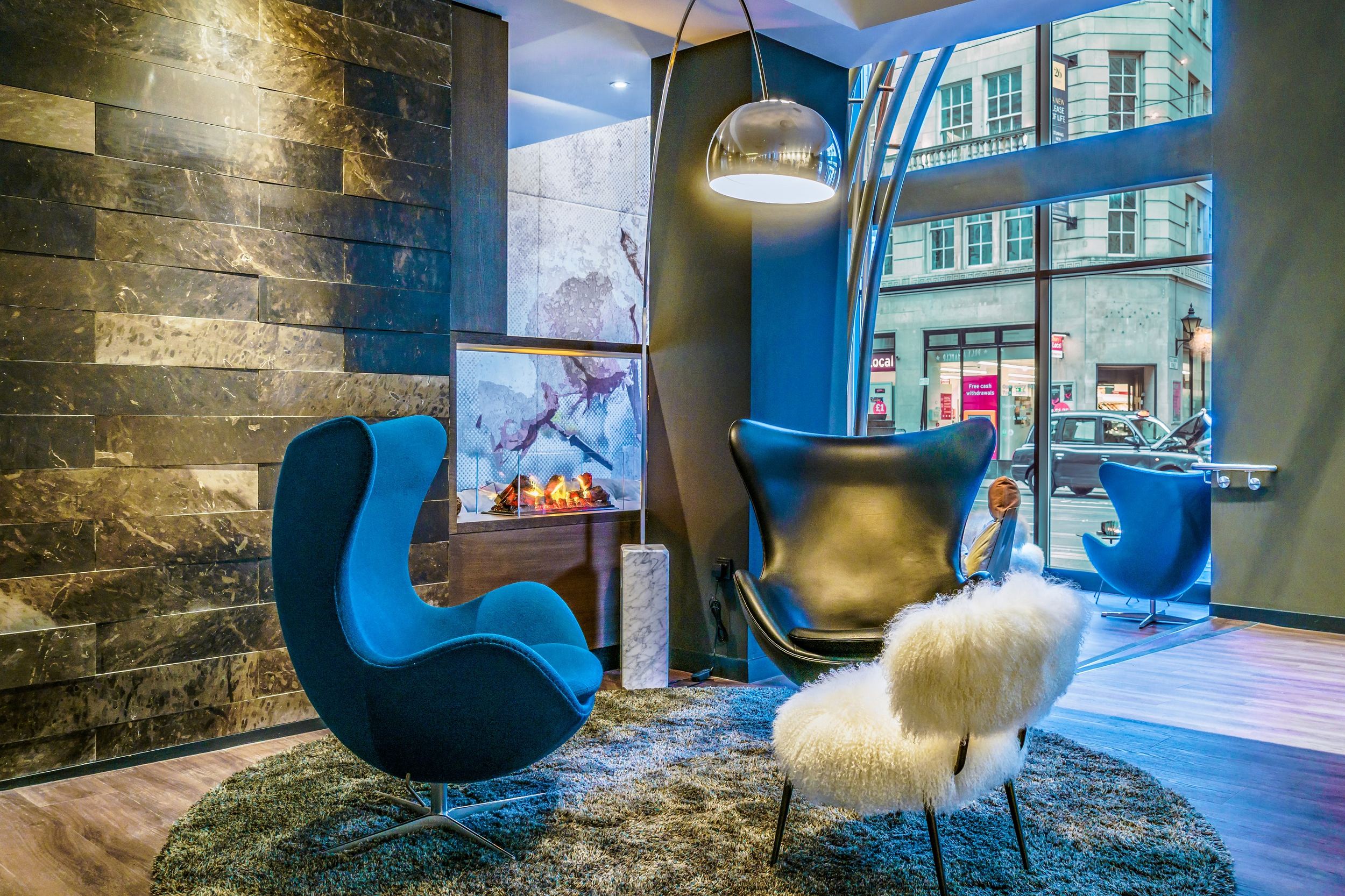 hotel Manchester Royal Exchange Motel One two egg chairs in front of a fake fireplace and large window front