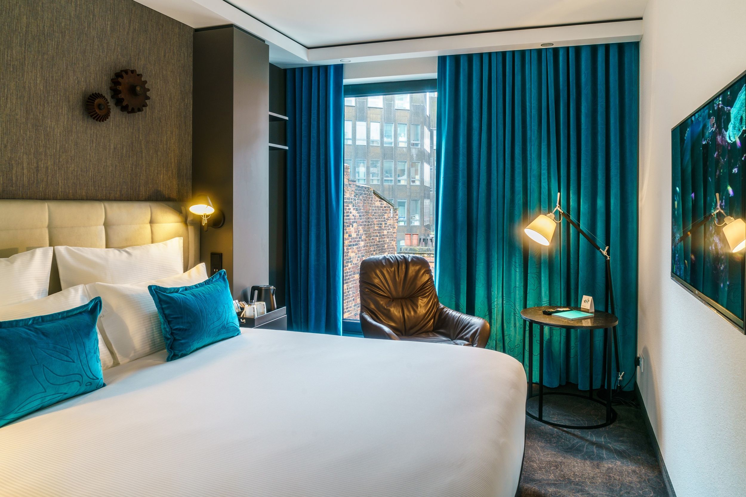 designhotel Manchester Royal Exchange Motel One bright room with double bed, armchair and TV on the wall