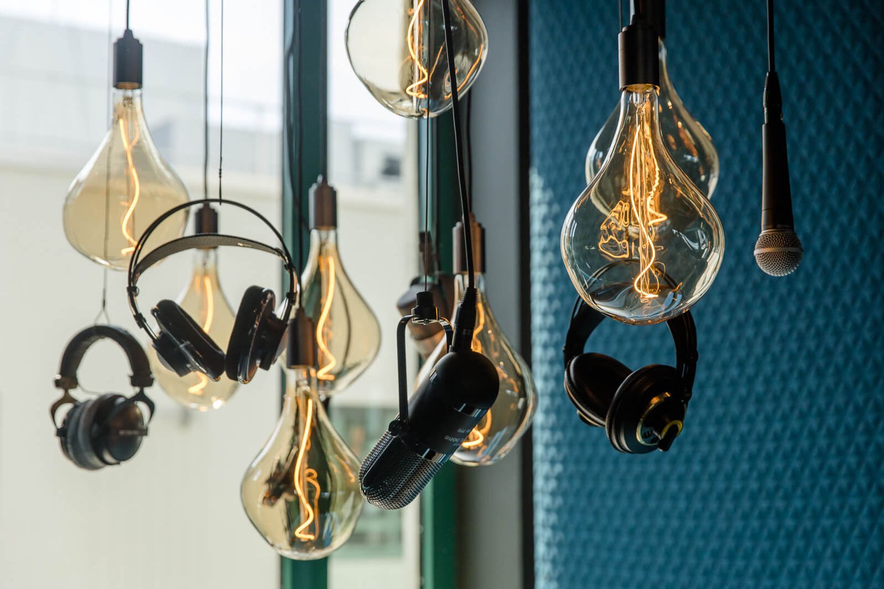 designhotel Mannheim Motel One close-up of light bulbs, microphones and headphones from the ceiling