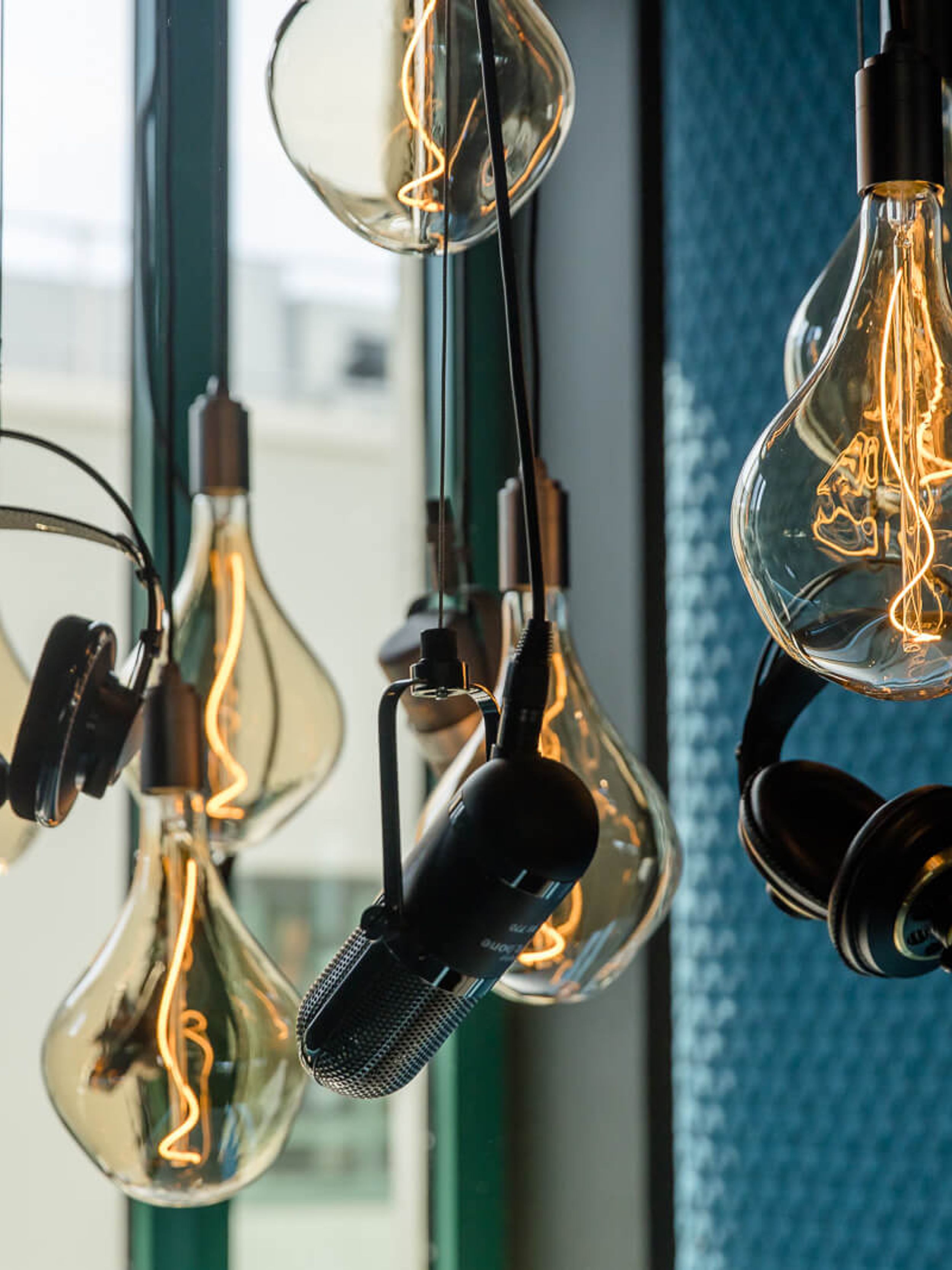 Designhotel Mannheim Motel One Nahaufnahme Glühbirnen, Mikrofone und Kopfhörer von der Decke