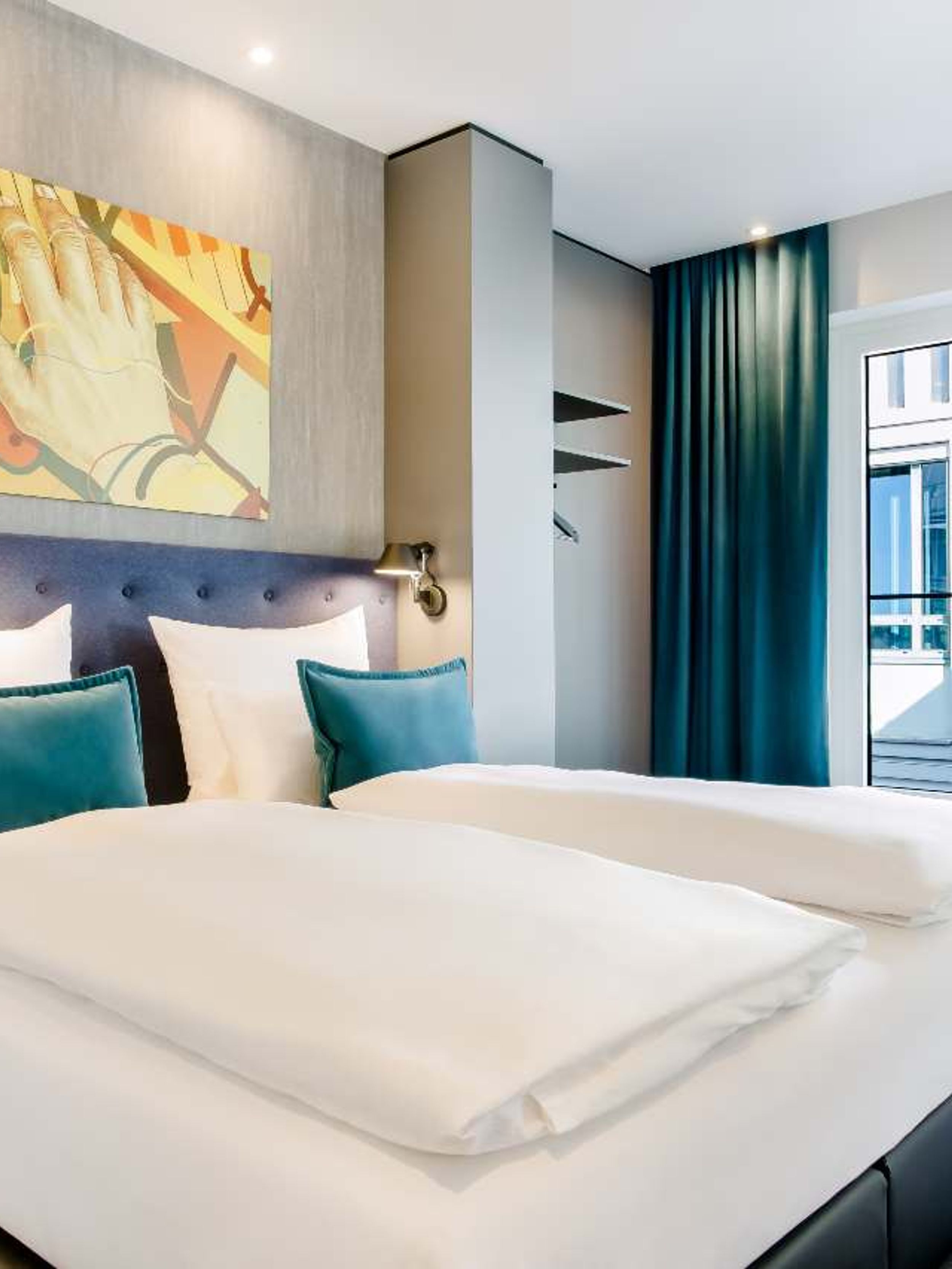 Hotel Mannheim Motel One Zimmer mit komfortablem Doppelbett und Sessel sowie Schreibtisch