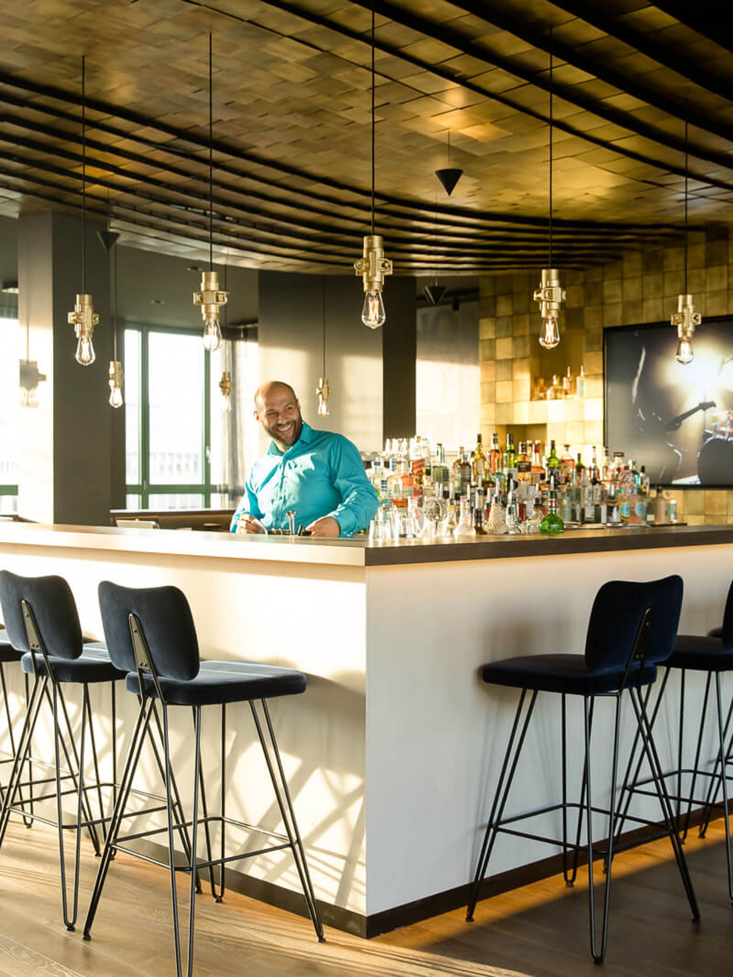 Hotel Mannheim Motel One Bar mit Barkeeper sowie mehreren Barhockern