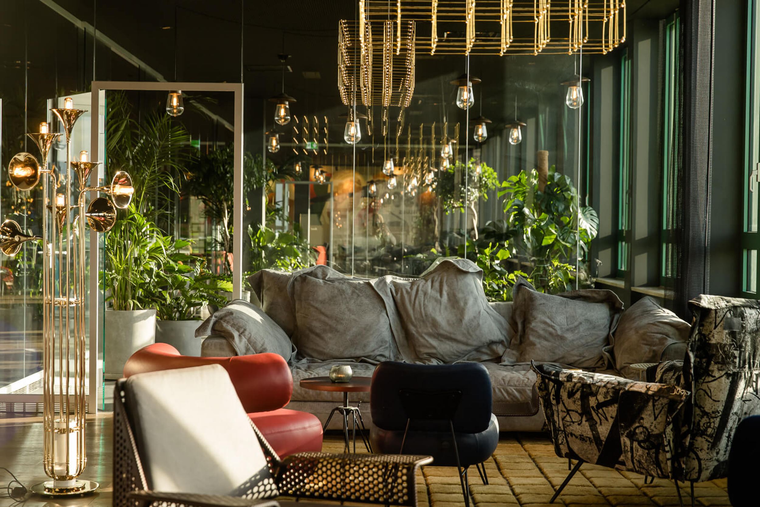 Hotel Mannheim Motel One lichtdurchflutete Lounge mit komfortabler Couch, Sesseln und vielen Pflanzen