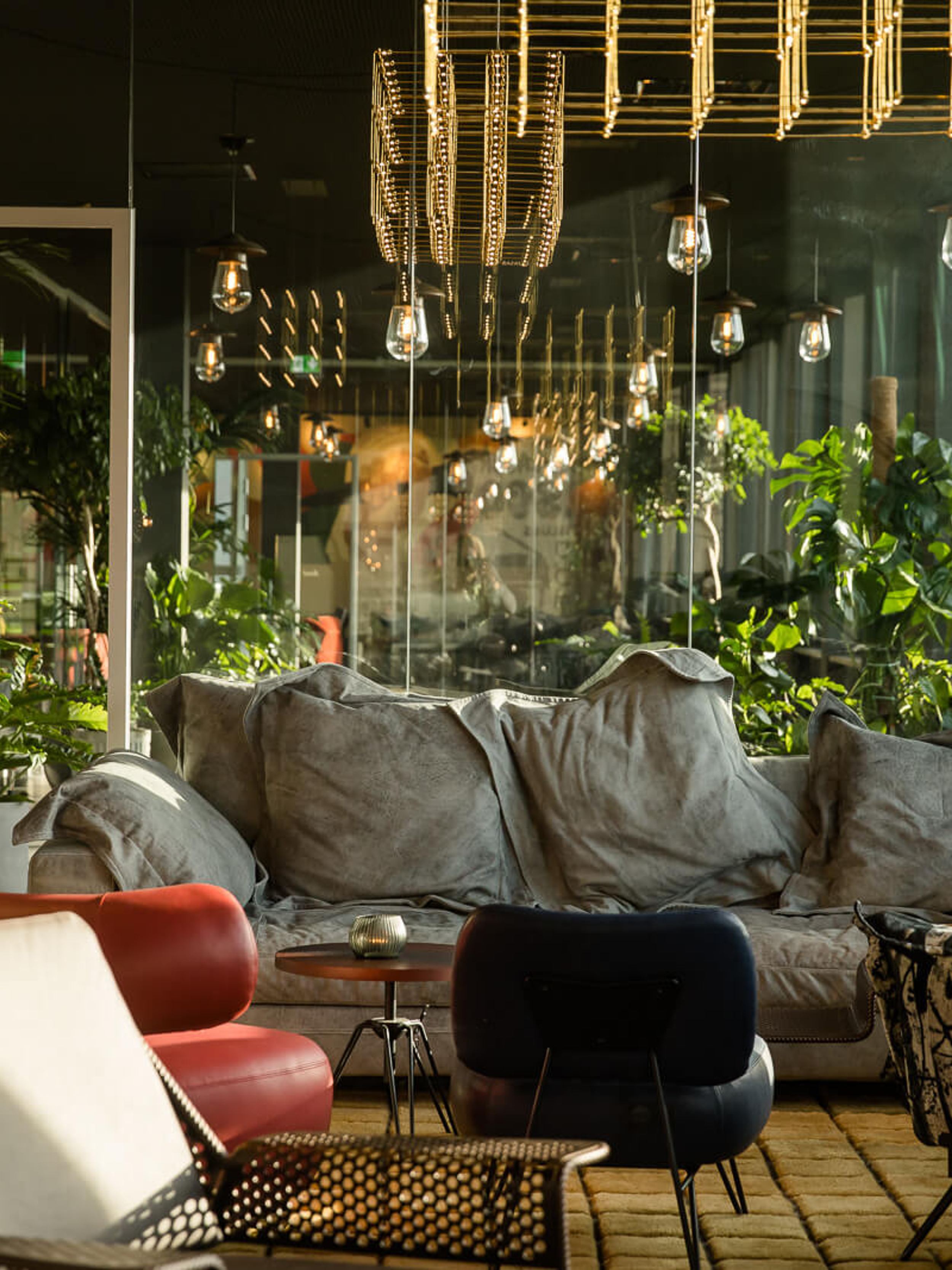 Hotel Mannheim Motel One lichtdurchflutete Lounge mit komfortabler Couch, Sesseln und vielen Pflanzen