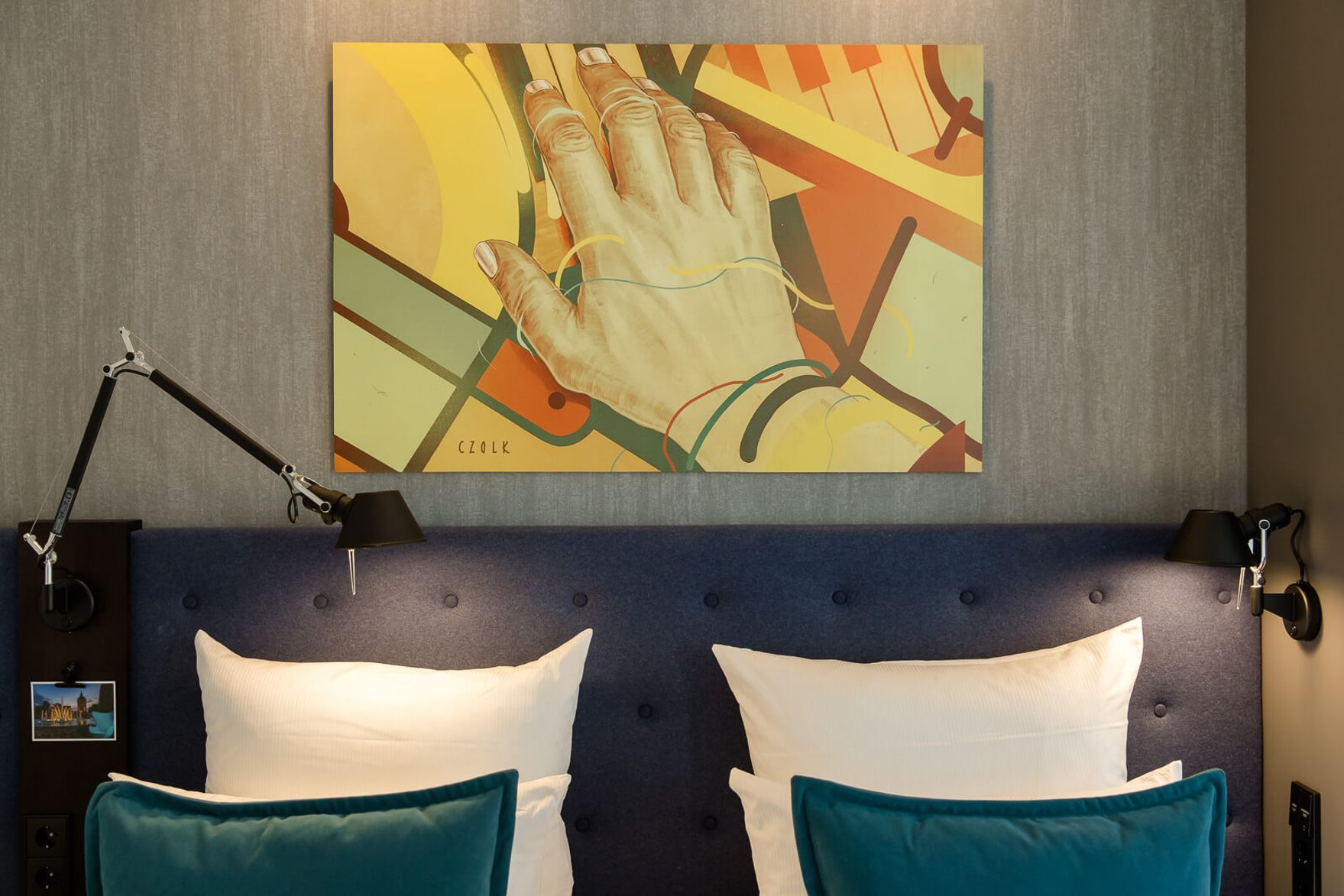 hotel Mannheim Motel One room with view of double bed with white pillows and decorative pillows in turquoise