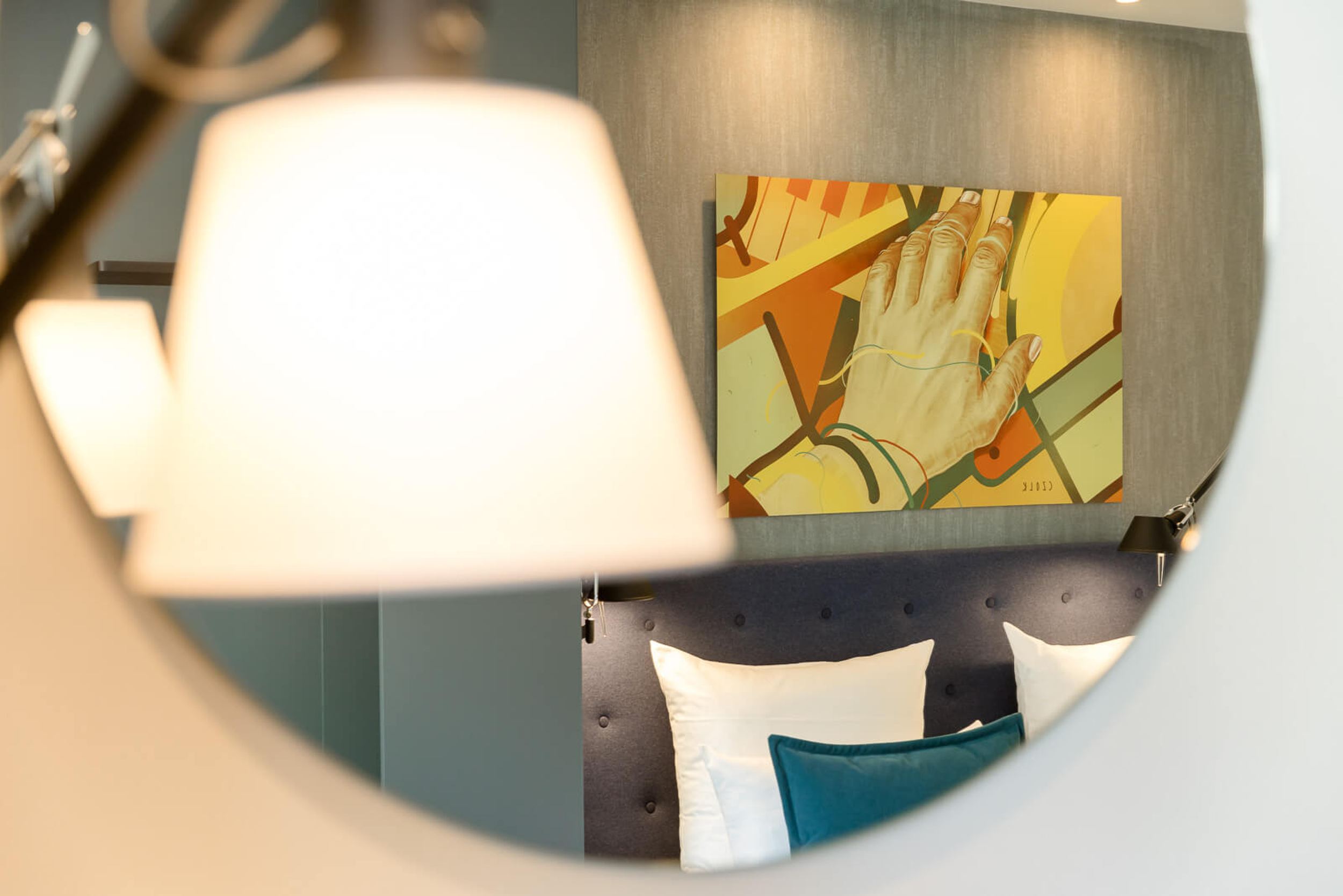 Designhotel Mannheim Motel One Blick durch Spiegel auf Kopfteil eines Bettes in Hotelzimmer