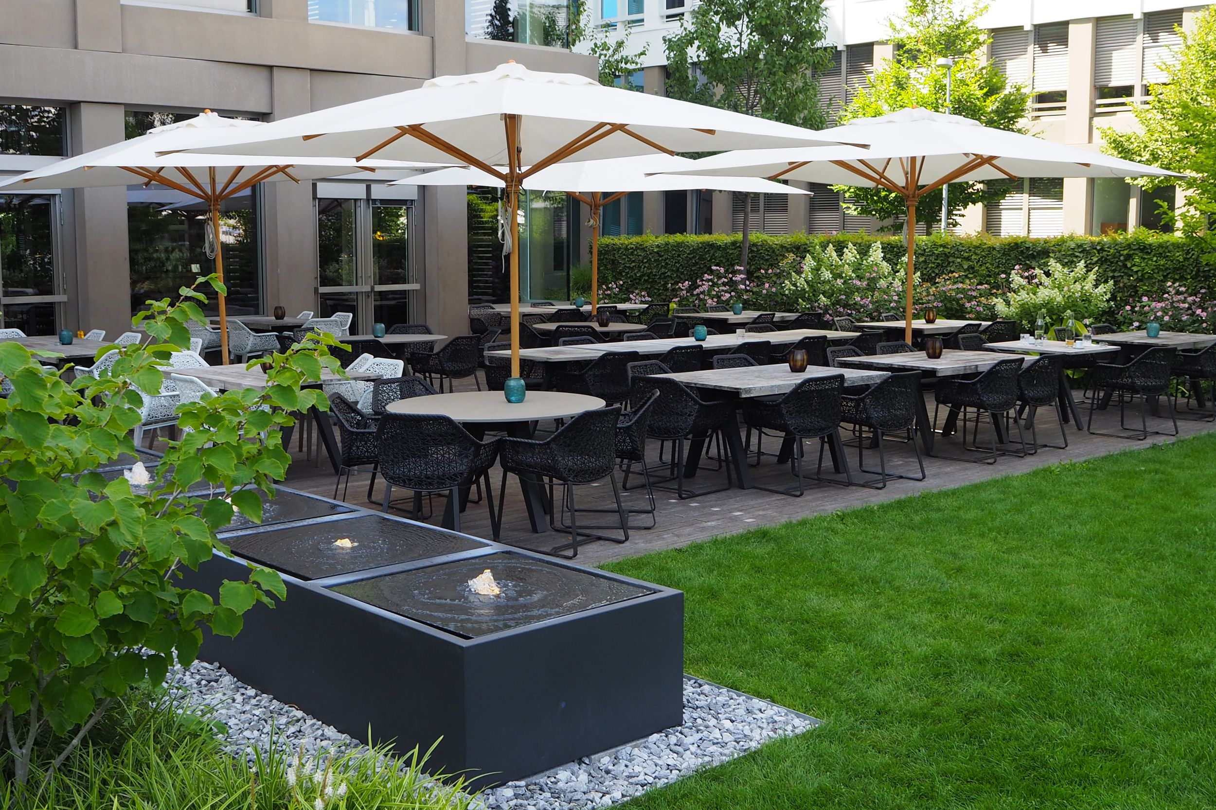 Design Hotel München Campus Motel One Terrasse mit Sitzgelegenheiten und Sonnenschirmen