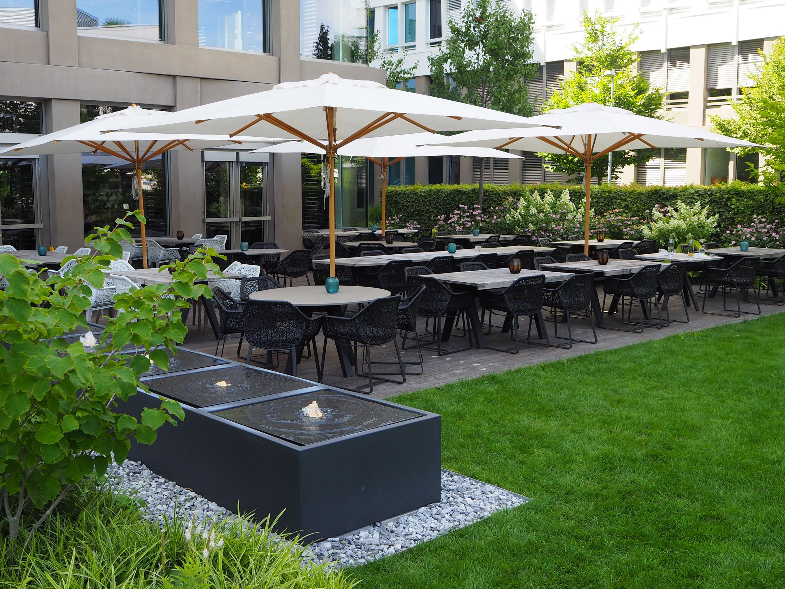 Design Hotel München Campus Motel One Terrasse mit Sitzgelegenheiten und Sonnenschirmen