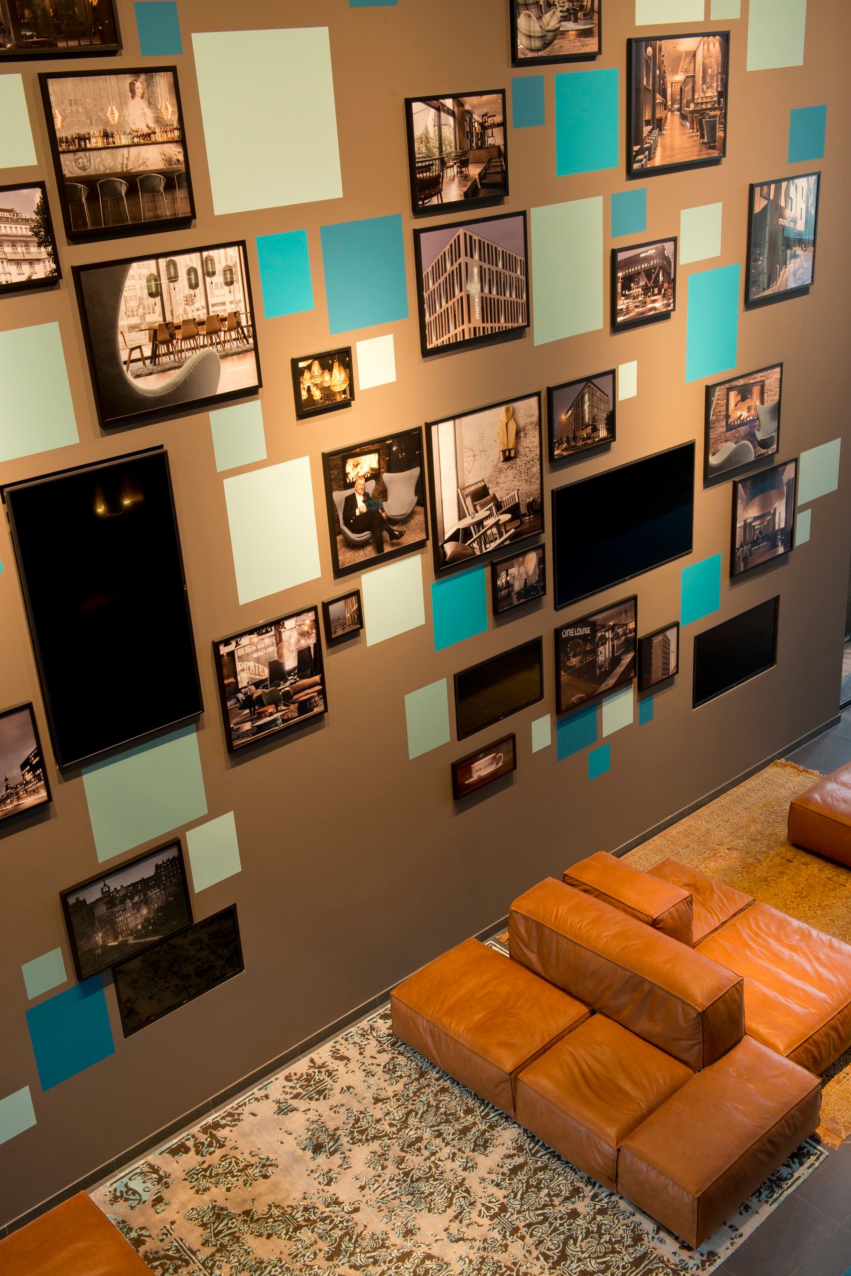 Hotel München Campus Motel One Blick von oben auf den Eingangsbereich mit Bildern und Sesseln