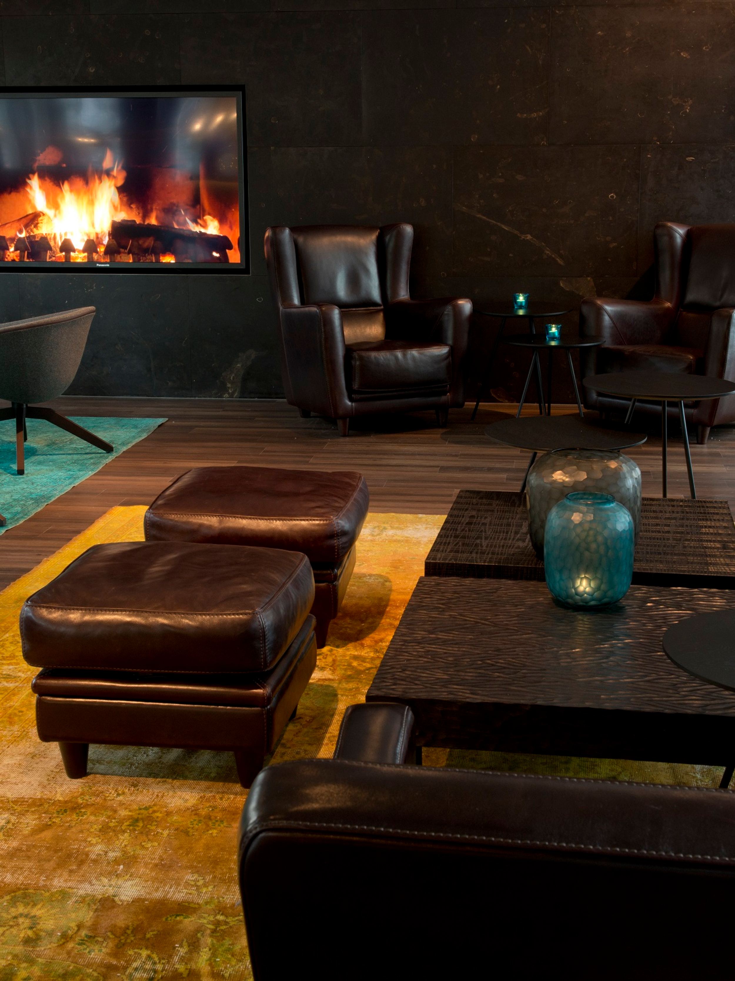 Hotel München Campus Motel One Lounge mit Sitzgelegenheiten und TV