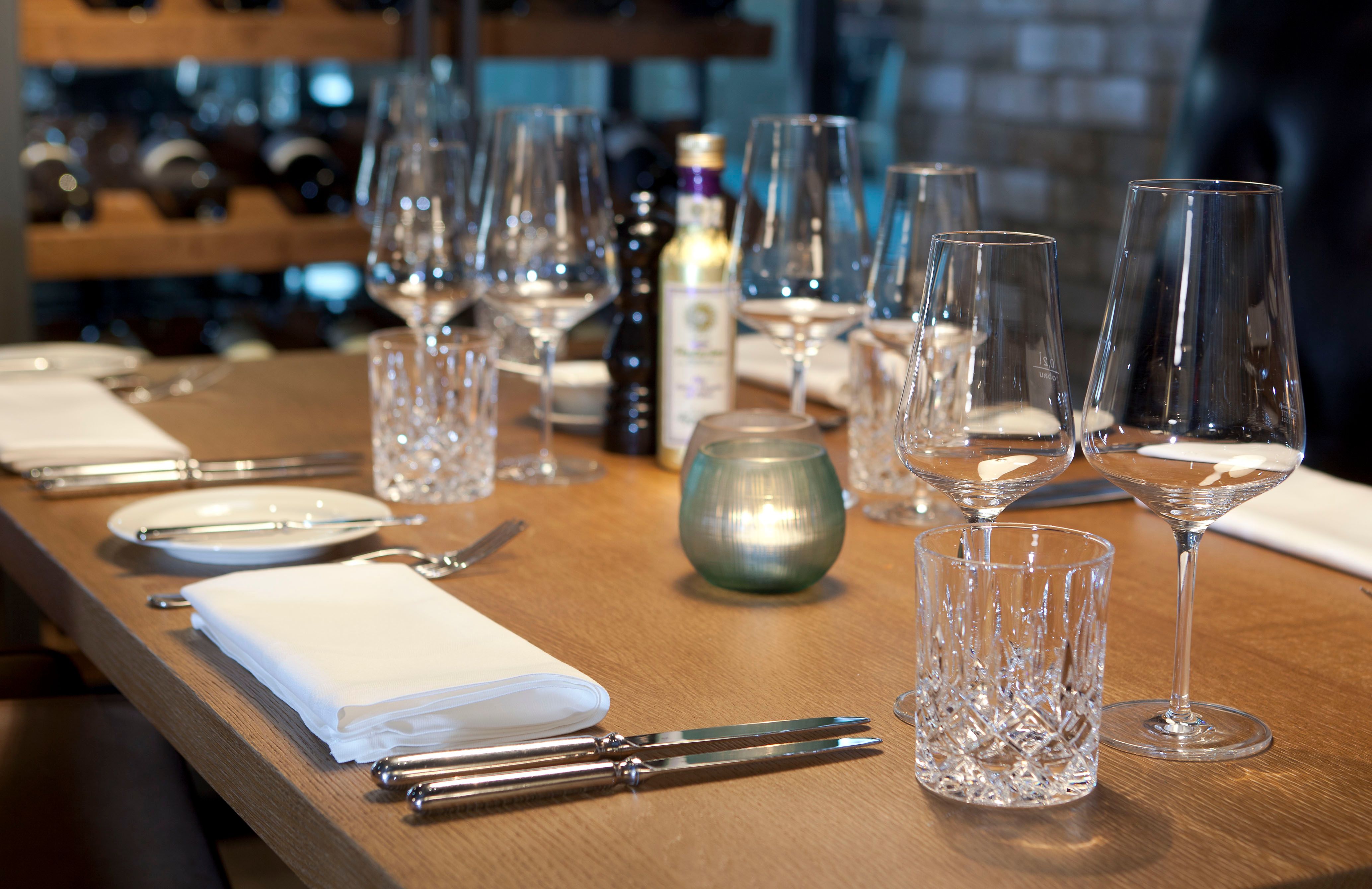 Hotel München Campus Motel One Nahaufnahme gedeckter Tisch mit Besteck und Weingläsern