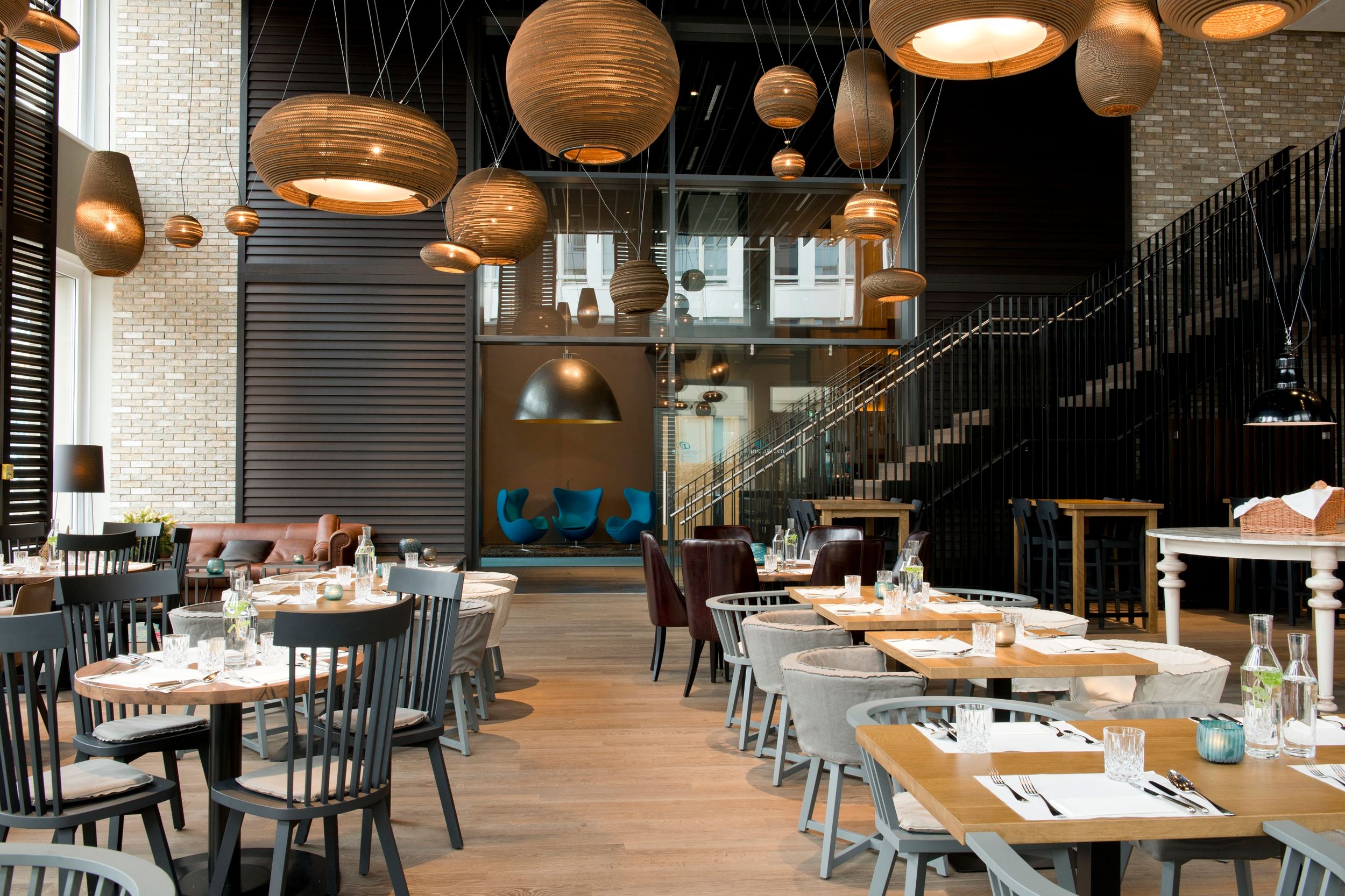 Designhotel München Campus Motel One Frühstücksraum mit mehreren Tischen und Stühlen