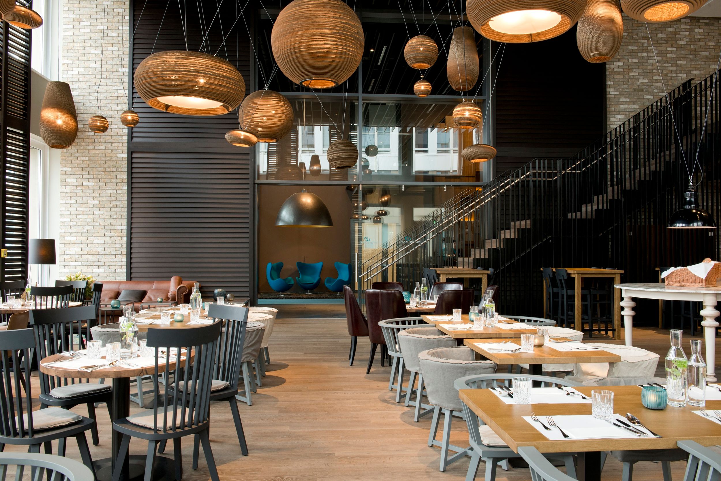 Designhotel München Campus Motel One Frühstücksraum mit mehreren Tischen und Stühlen