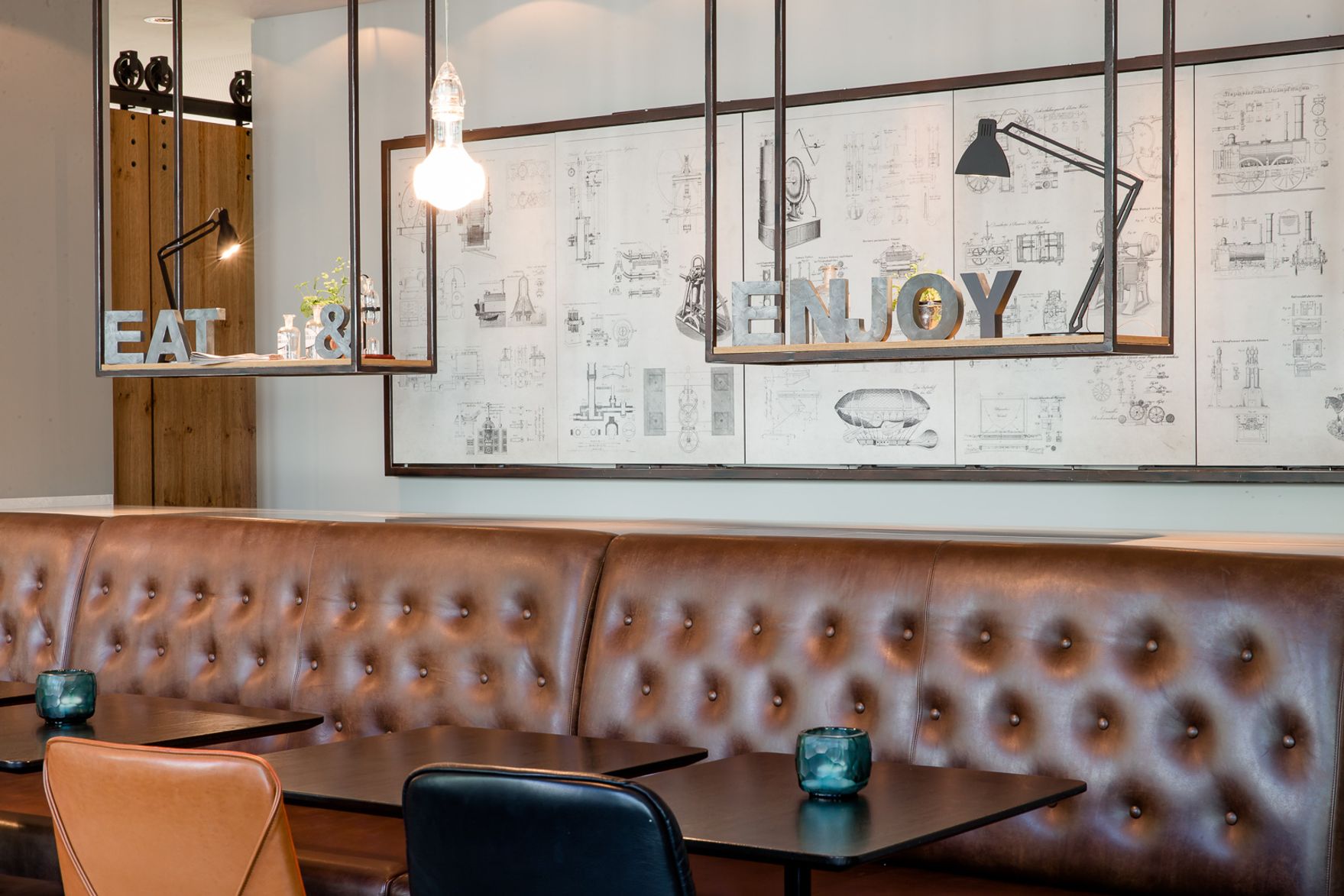 Designhotel München Deutsches Museum Motel One Nahaufnahme auf Couch sowie offenes Regal mit Dekoration