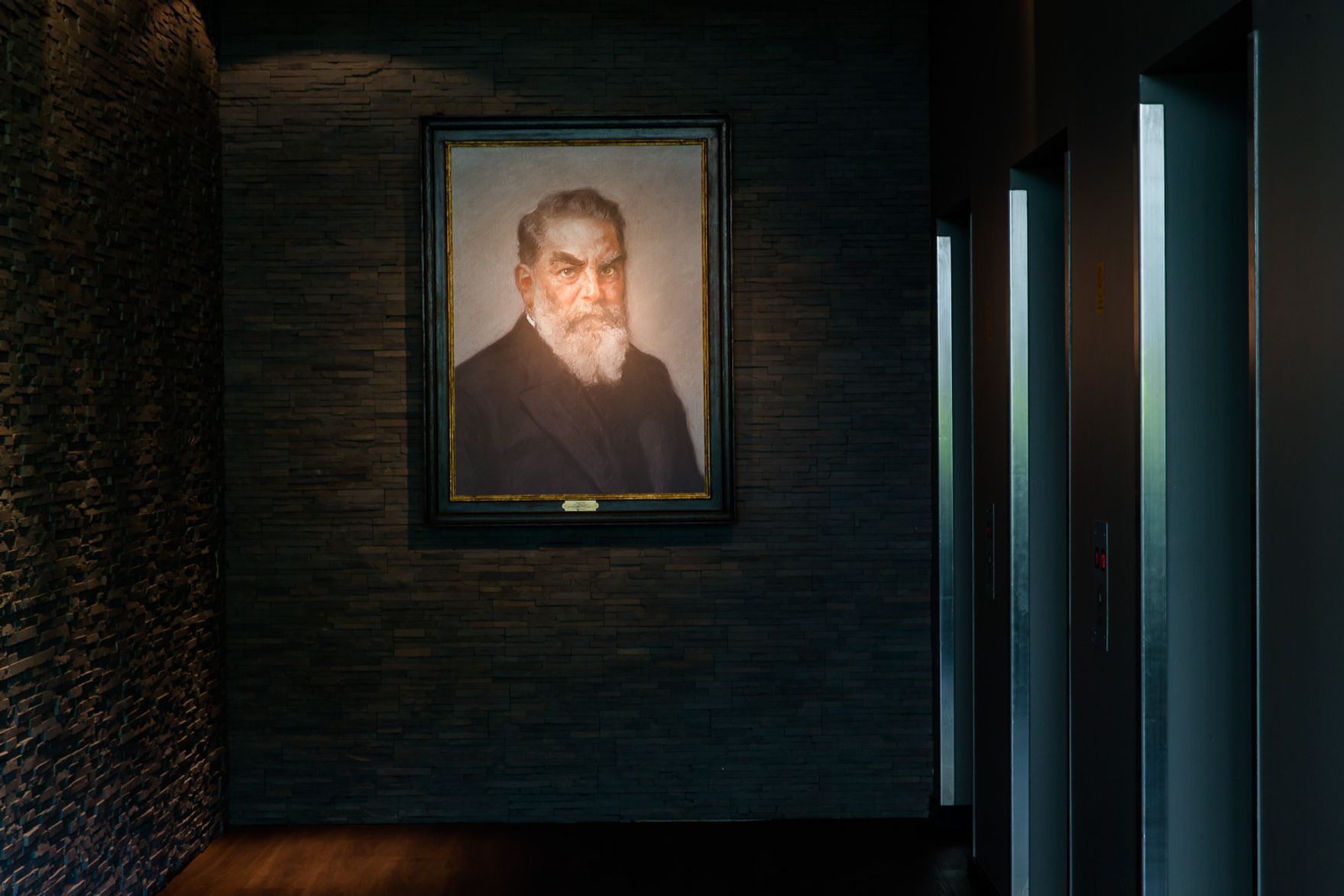 Designhotel München Deutsches Museum Motel One Portrait eines Mannes an der Wand nahe der Aufzüge
