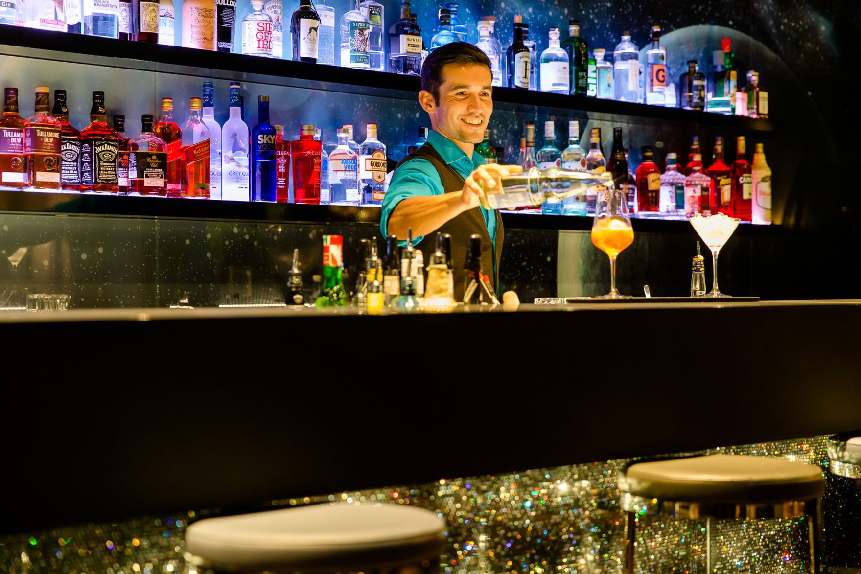 Designhotel München Deutsches Museum Motel One Barkeeper hinter der Bar bei der Zubereitung eines Drinks