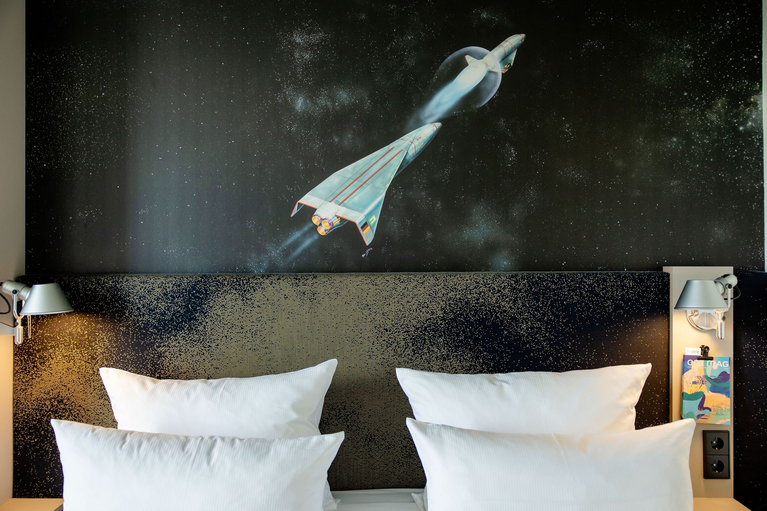 Hotel München Deutsches Museum Motel One Nahaufnahme Doppelbett mit Kissen sowie großes Wandbild