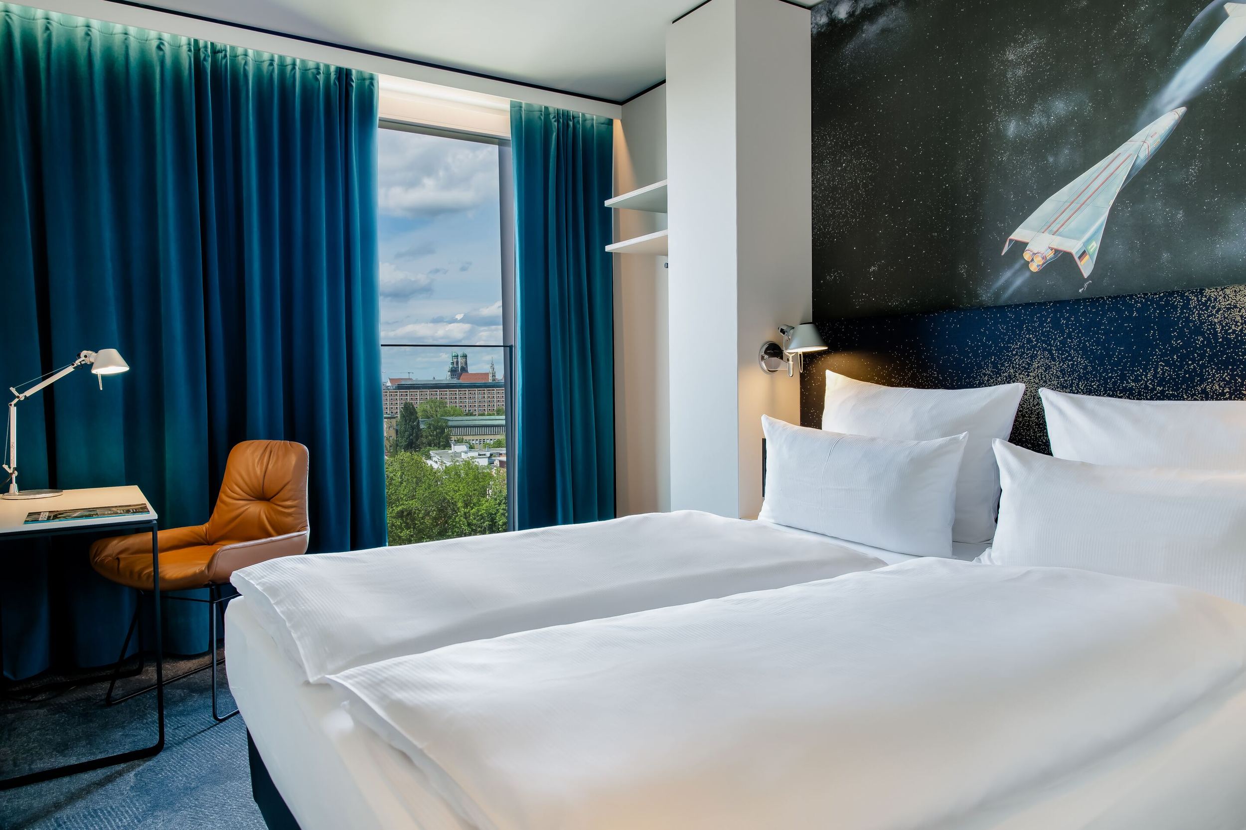 Hotel München Deutsches Museum Motel One lichtdurchflutetes Doppelzimmer mit Schreibtisch und Stuhl