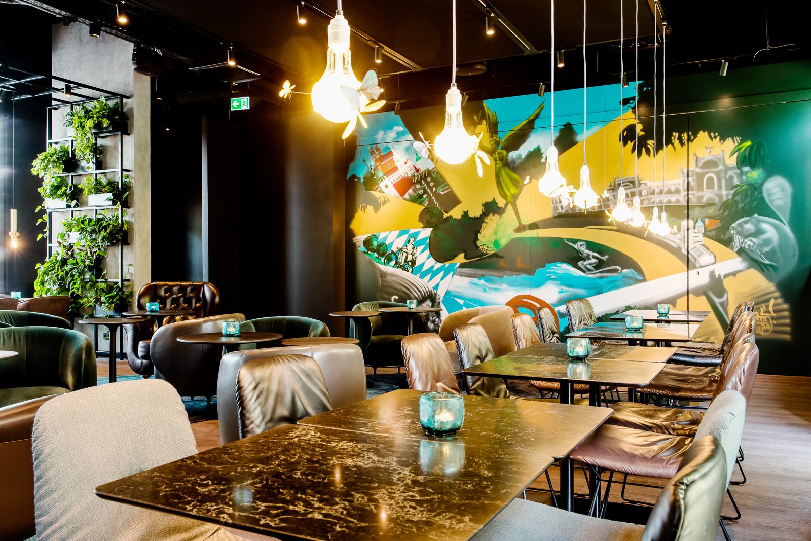 Hotel München East Side Motel One Lounge mit mehreren Tischen und Stühlen