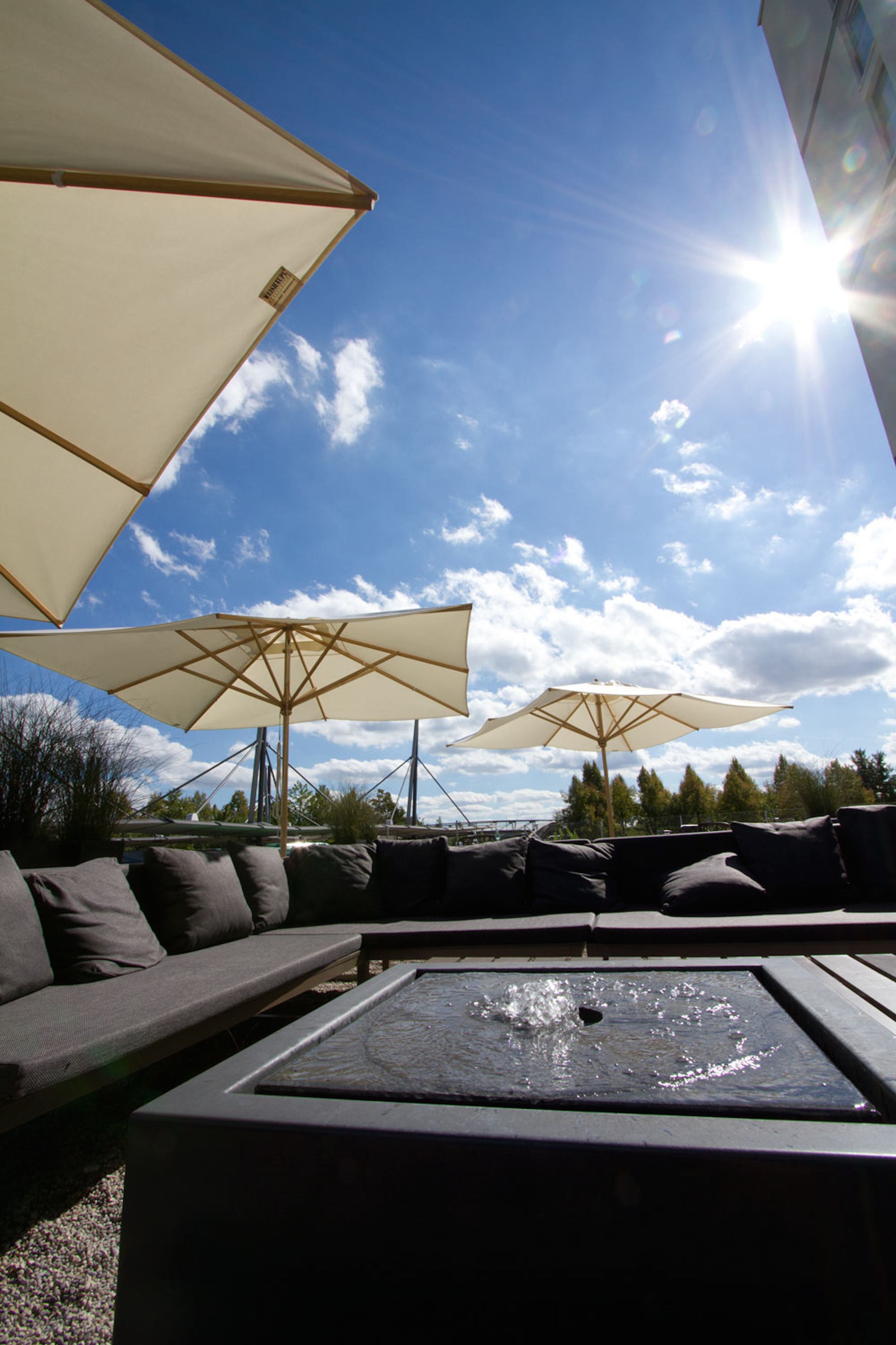 Hotel München Garching Motel One Außenbereich mit Sitzgelegenheiten