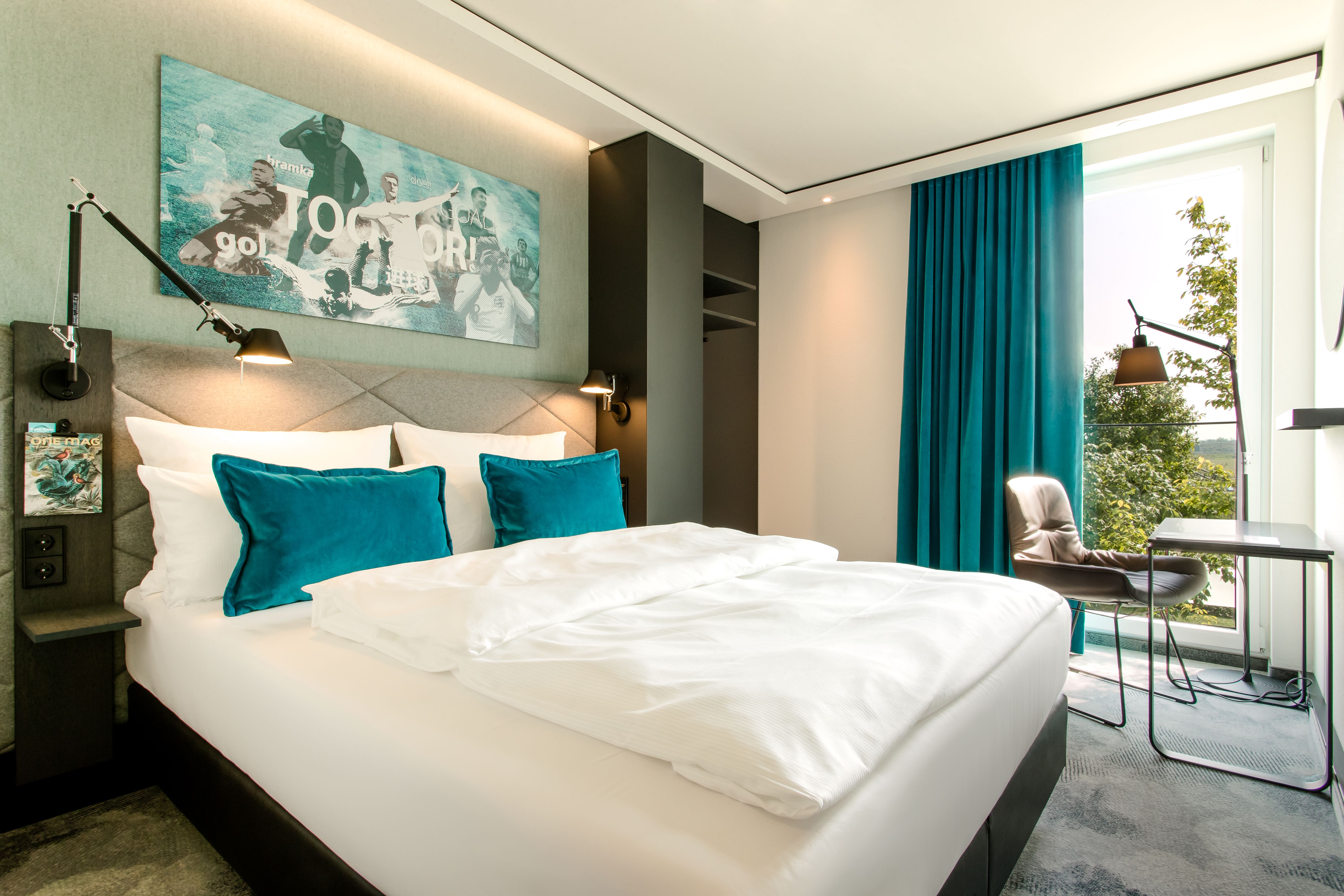 designhotel Garching Motel One bright double room with decorative cushions and floor-to-ceiling window