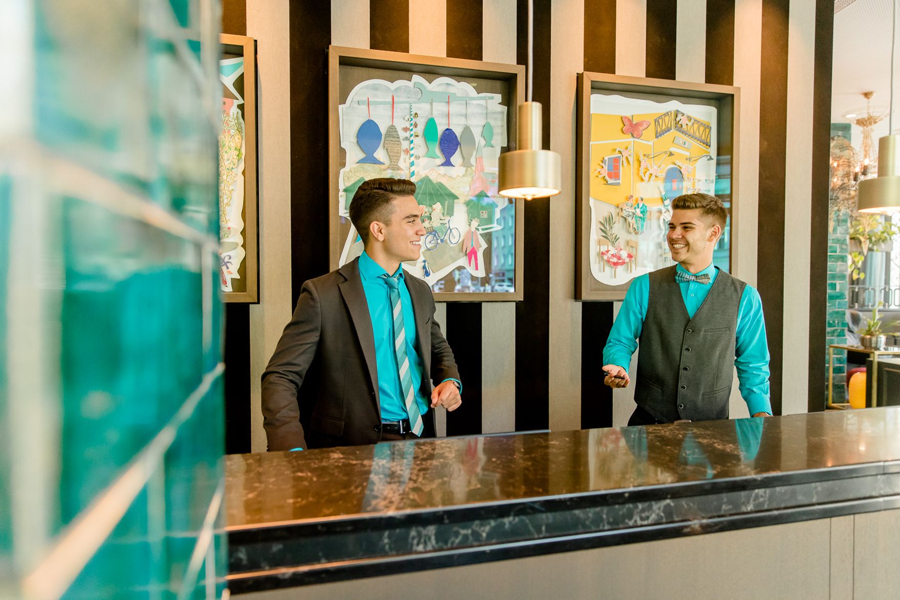 Designhotel München Haidhausen Motel One zwei lächelnde Mitarbeiter an der Rezeption