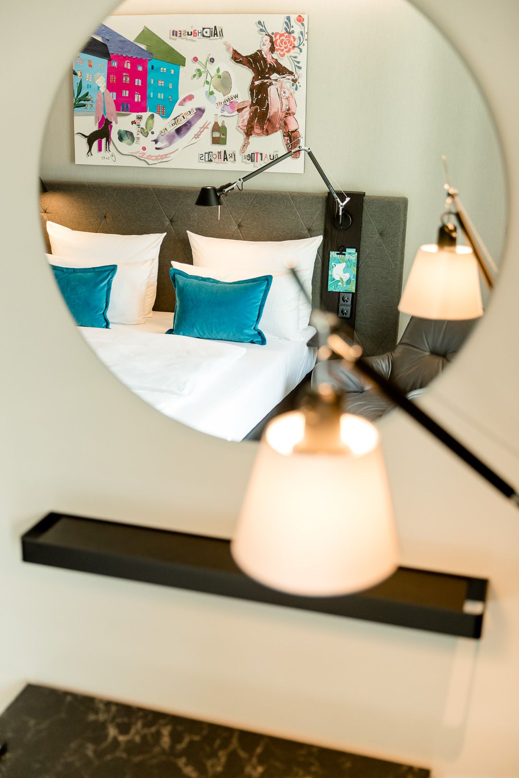 Designhotel München Haidhausen Motel One Blick durch runden Spiegel auf Doppelbett