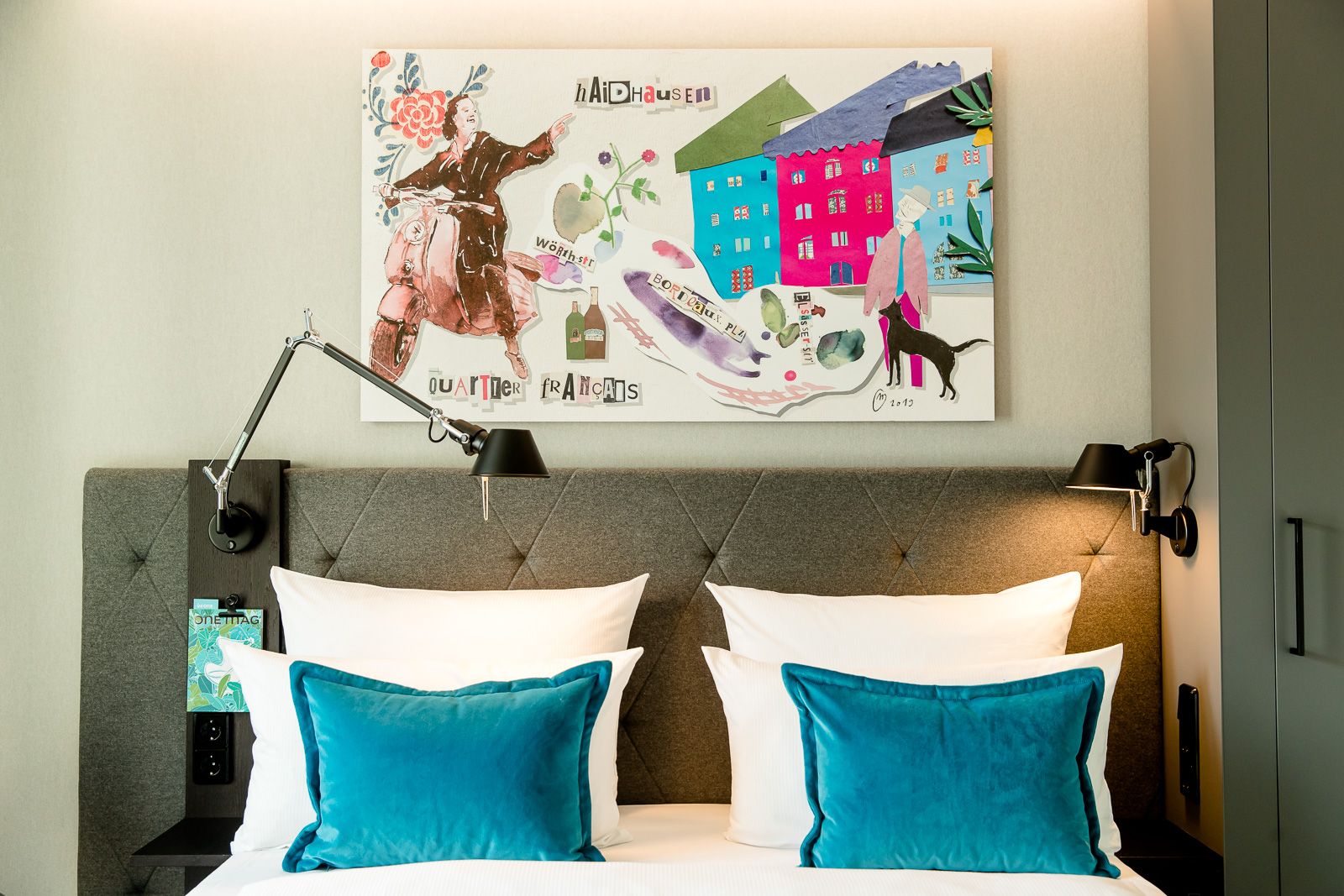 Designhotel München Haidhausen Motel One Doppelbett mit Zierkissen und Bild über dem Bett